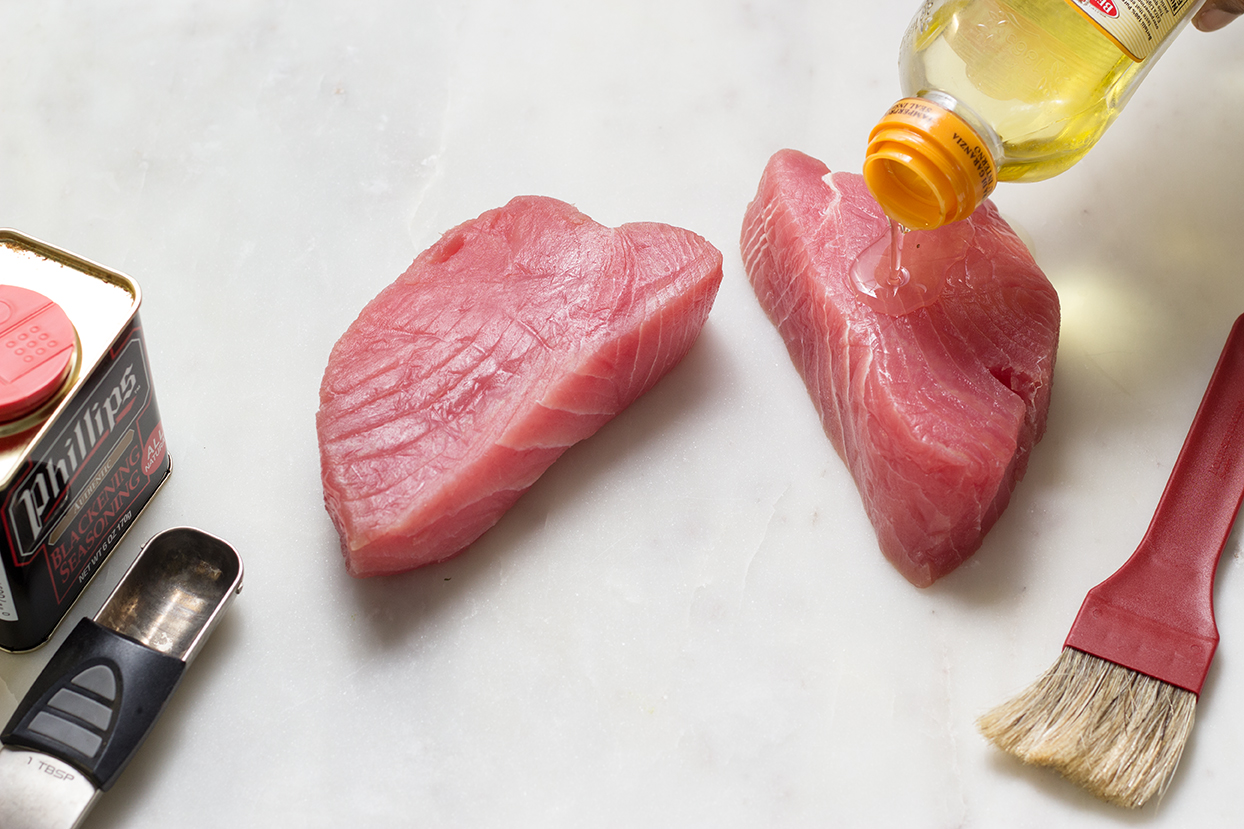 Wash, pat dry, then brush olive oil on tuna steaks.