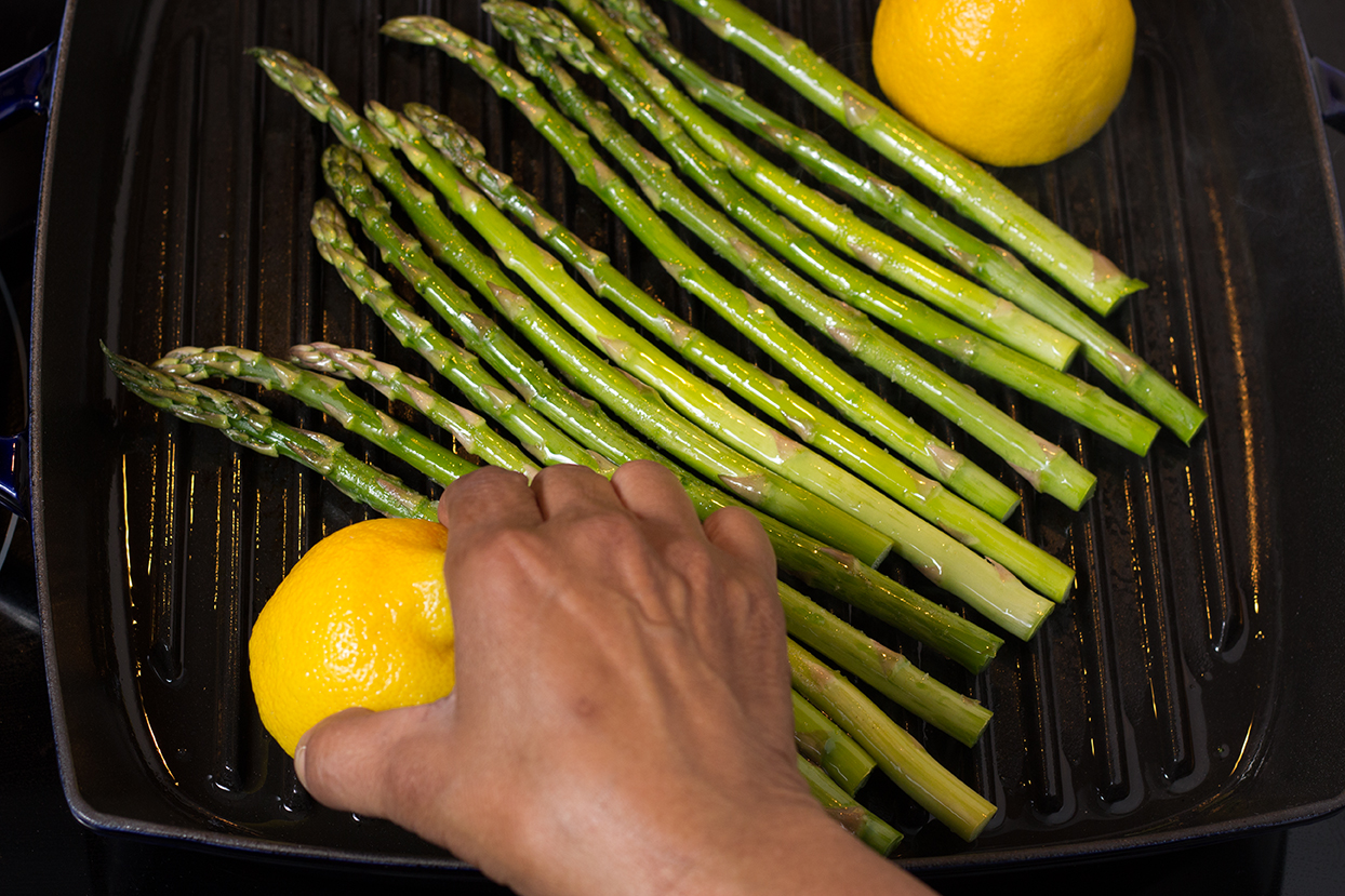 Add asparagus to center of a very hot grill pan. Cook for 4 minutes on one side. Grill cut lemons (optional).