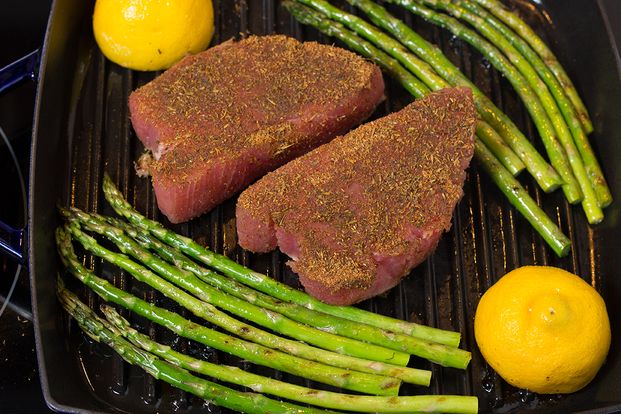 Turn over asparagus and push to sides. Add tuna steaks to the center of the grill pan.