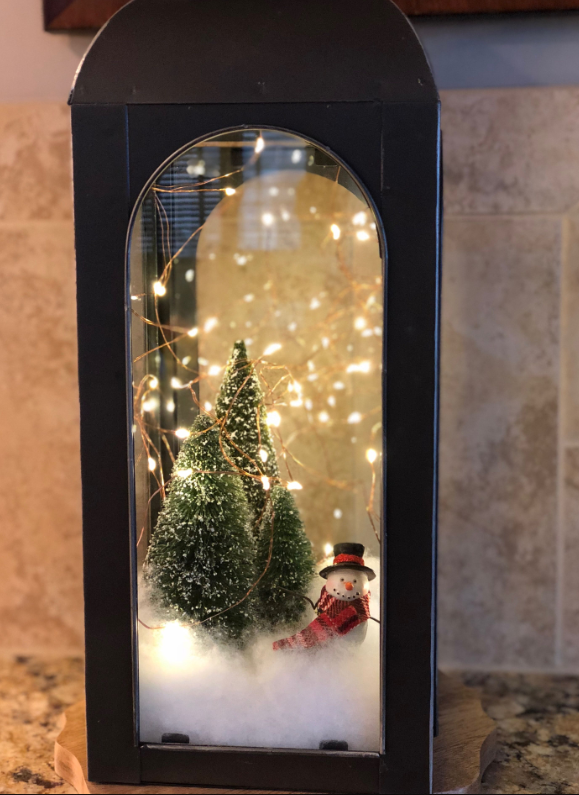 Christmas vignette with snowman and lights in lantern image source