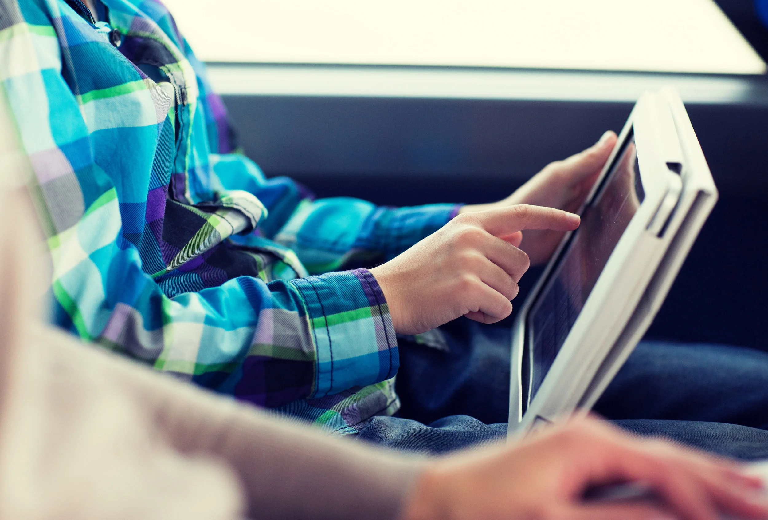 close-up-of-boy-with-tablet-pc-in-travel-bus-PDR2ZVS.jpg