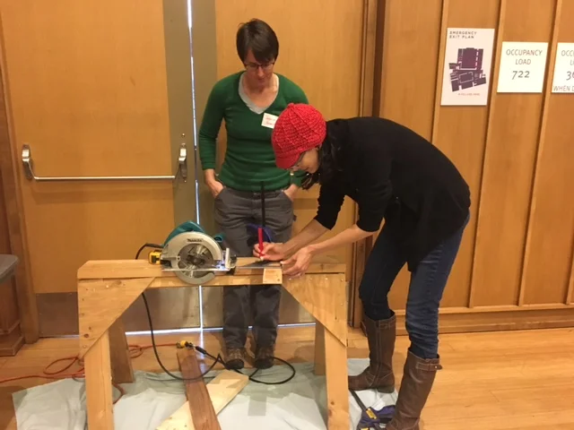 Aviva Krauthammer learns to use a circular saw from Jessica at the Silver Spring Timebank Skills Share in January 2017. 