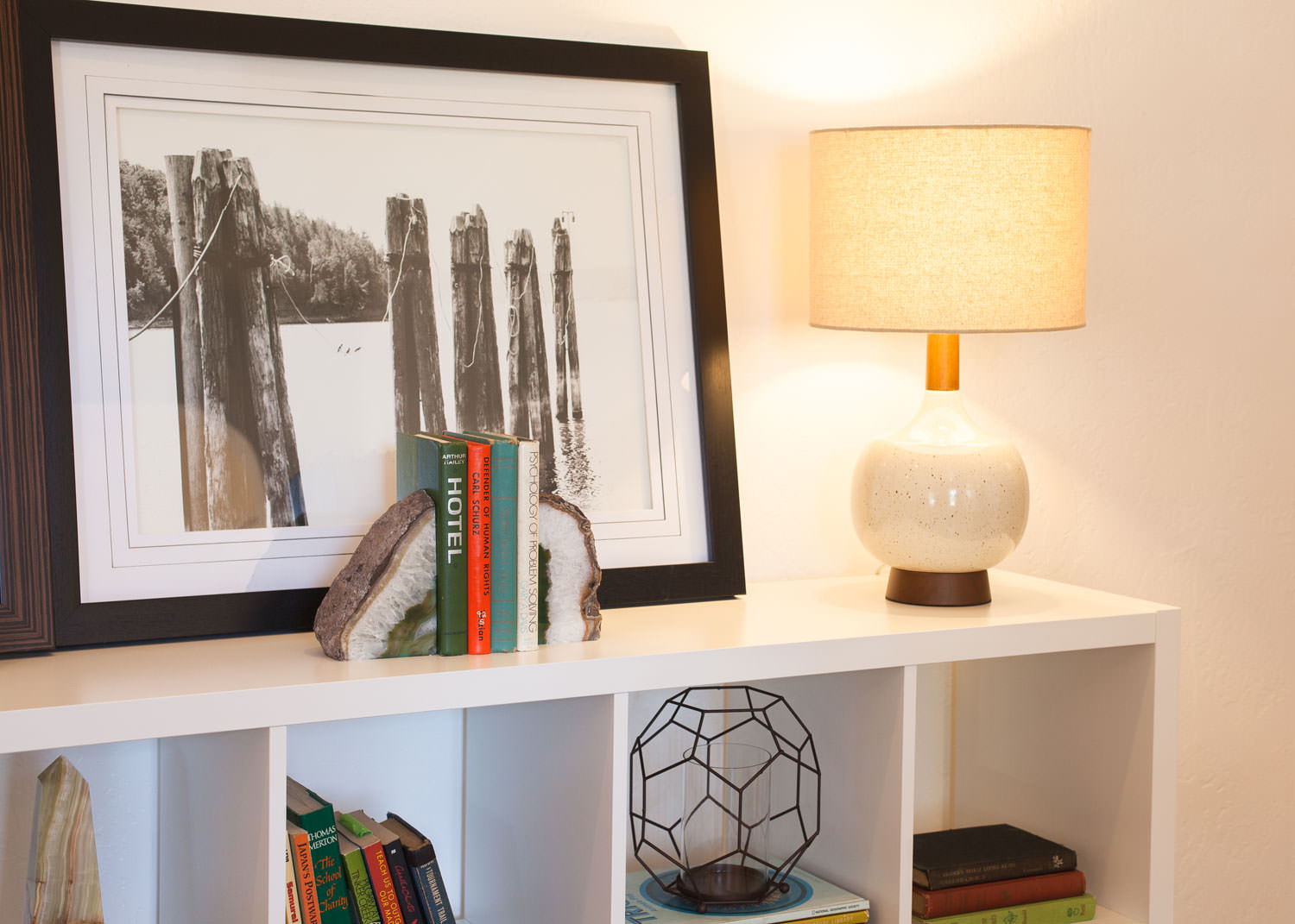 A table lamp gives warm ambiance to a space, especially when it can be used as decor on a bookshelf. Image: James Stewart