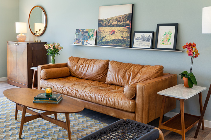 A gorgeous camel-leather sofa pairs with sleek marble finishes in this lofty living room.