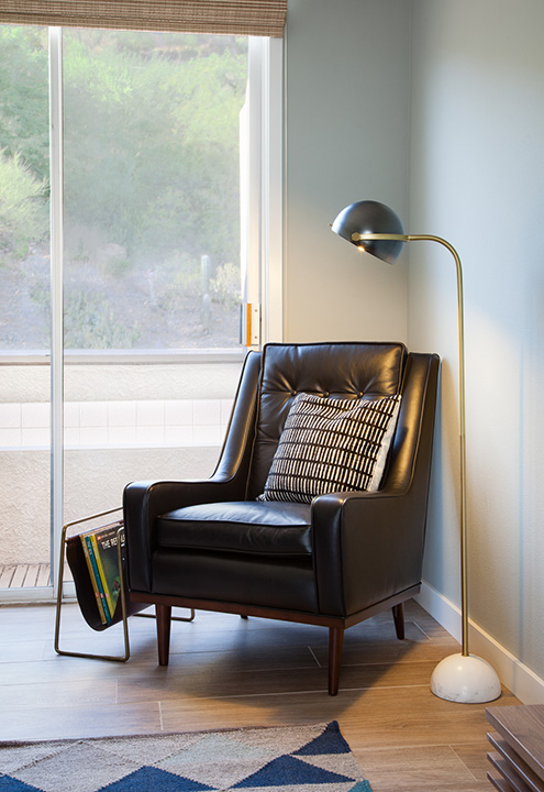 A masculine lounge chair becomes a comfy spot to hang out within this office space.