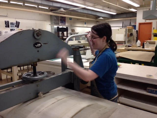  After aligning the print paper over the stone, I cover it with newsprint and the protective plastic covering. The press bar is greased so that the stone can still be moved through the press once the pressure has been set. Setting the pressure too hi