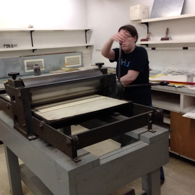  Here I've already laid the plate on the press, covering it with a damp piece of heavy paper to print. On top of that there are a few layers of newsprint to absorb the excess moisture from the damp paper.&nbsp;After laying down the felt cushions, I c