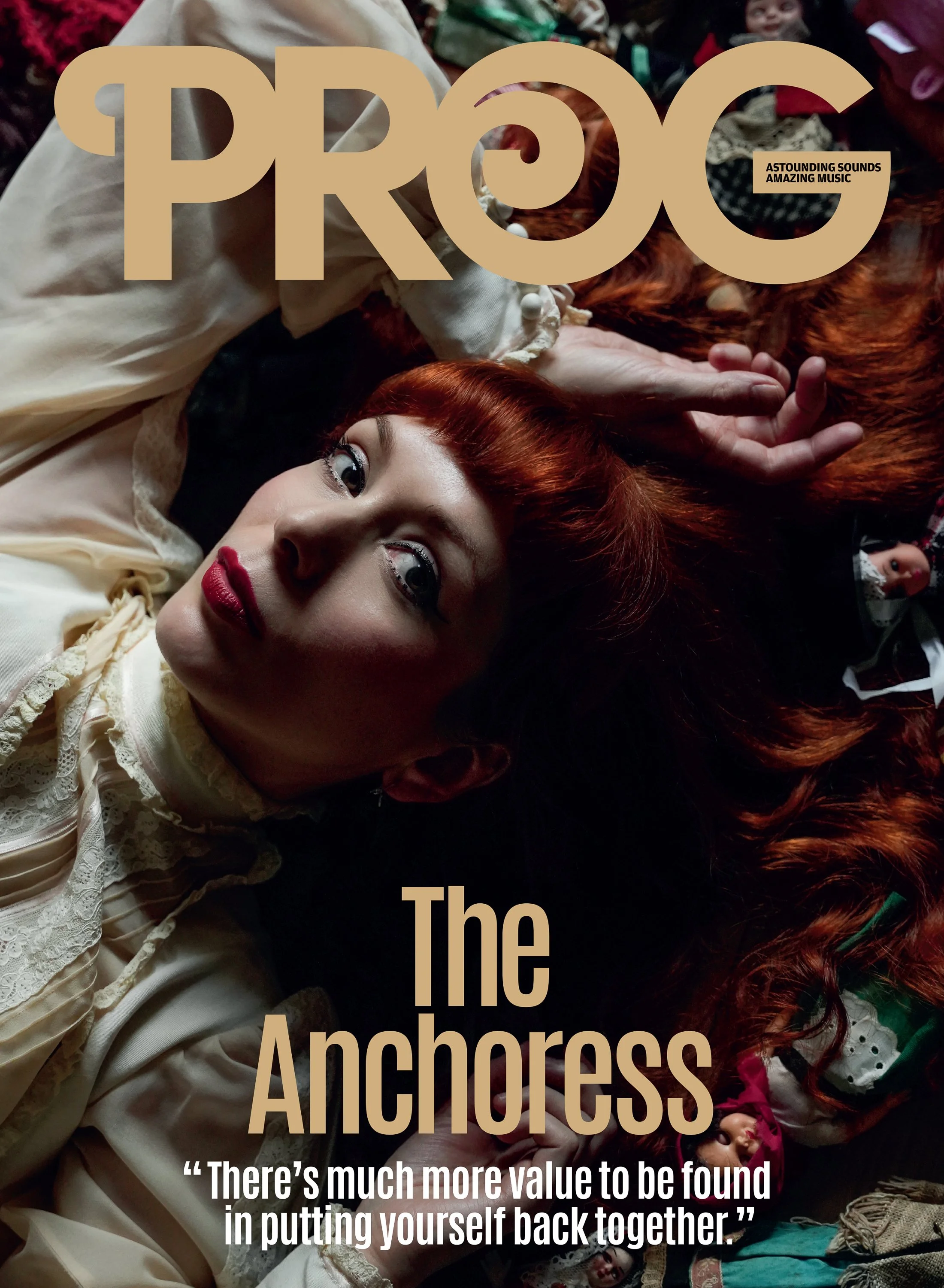 A woman with red hair lying on the ground surrounded by dolls and toys. Overlaid text reads 'PROG The Anchors' and a quote: 'There's much more value to be found in putting yourself back together.'