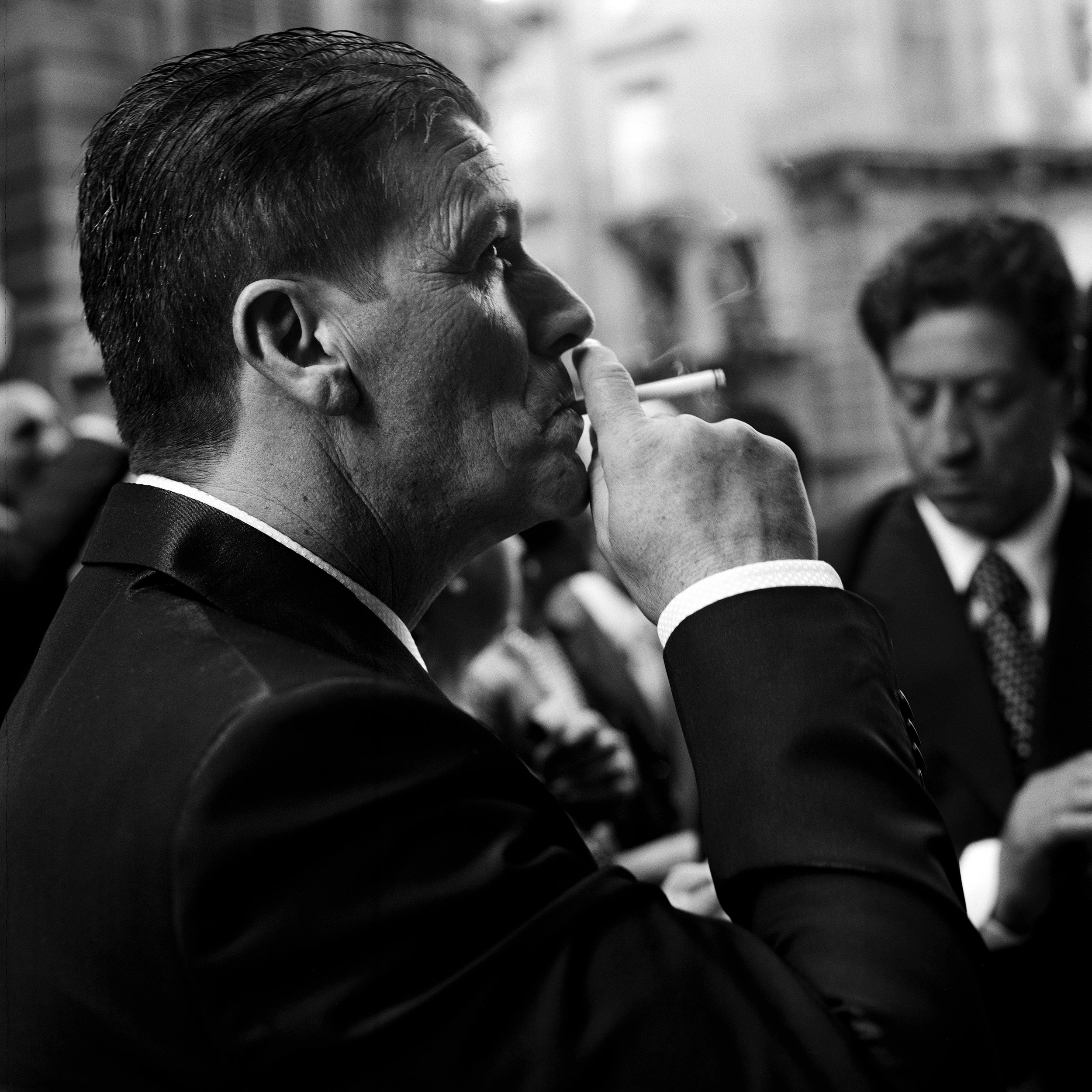  A wedding invitee enjoys a cigarette outside the church. 