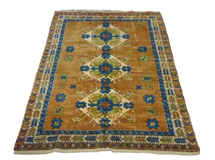 Wool Rug with energetic blue, olive green &amp; sand on camel ground. Measures 7&rsquo;4&rdquo; x 5&rsquo;4&rdquo; (including fringe)