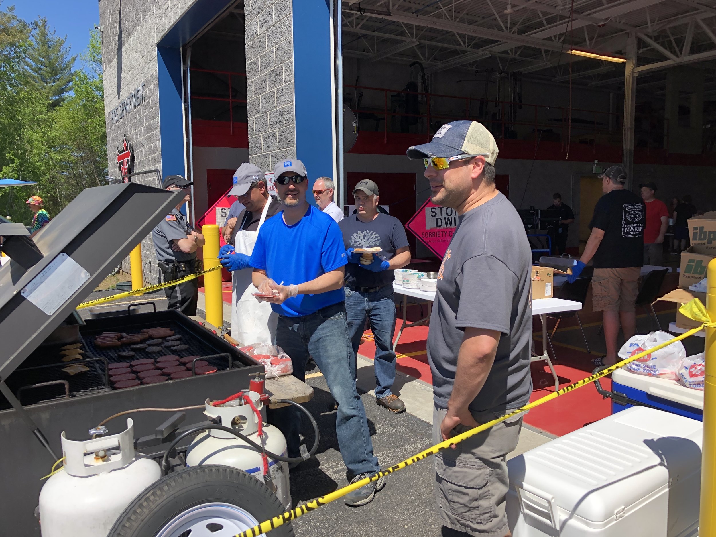   Fire Chief Royce Cole was keeping a close eye Saturday on the food preparation skills of volunteer Rick Reandeau and Police Chief Eric Proulx, who were working the police department's grill at the 13th annual Bike Rodeo.  