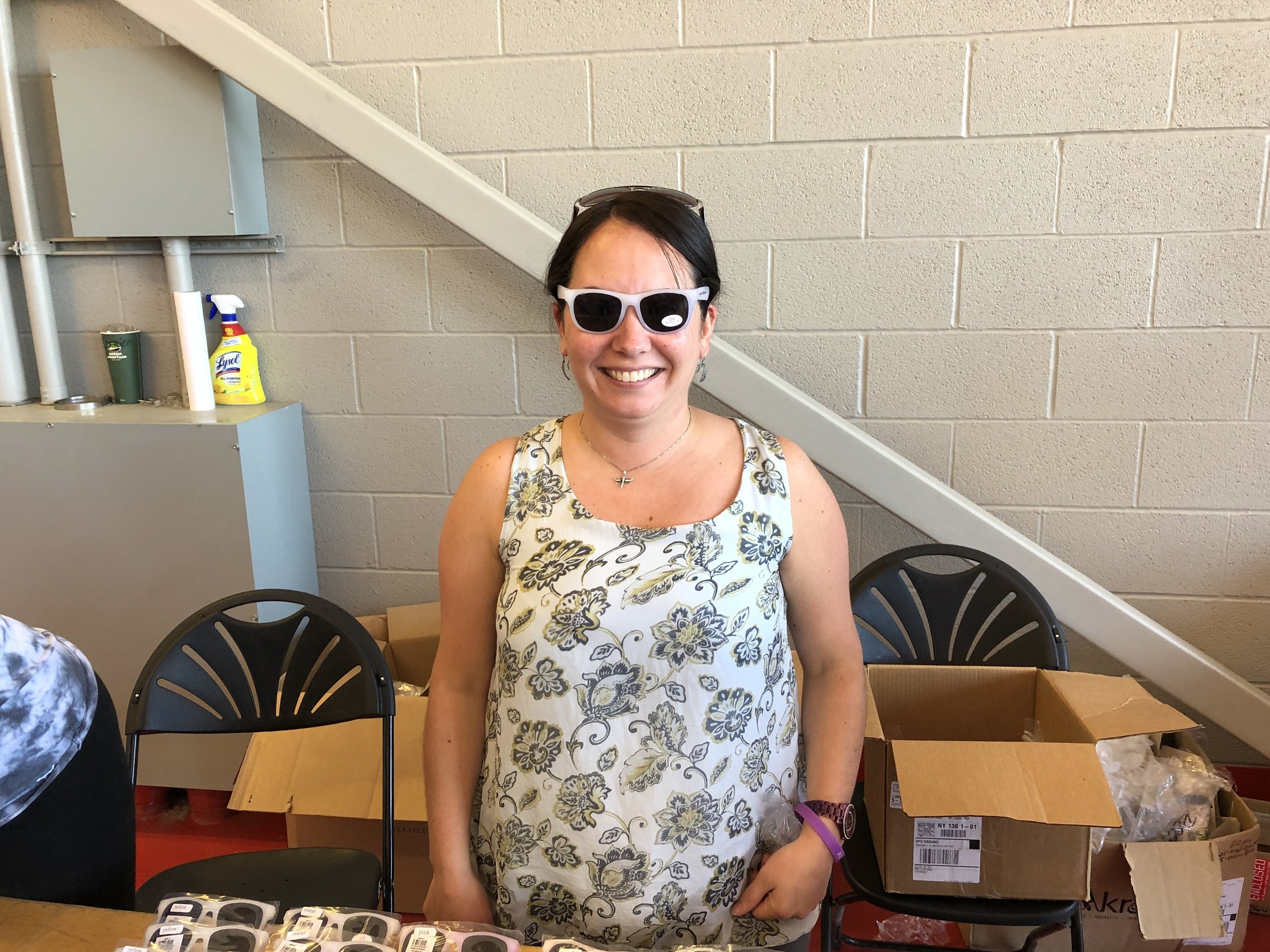   Amanda Amell was one of the volunteers distributing a handful of police department souvenirs including sun glasses, which she was trying on, frisbees, digital wrist lights, water bottles, all that could be carried home in a nice PD bag.   