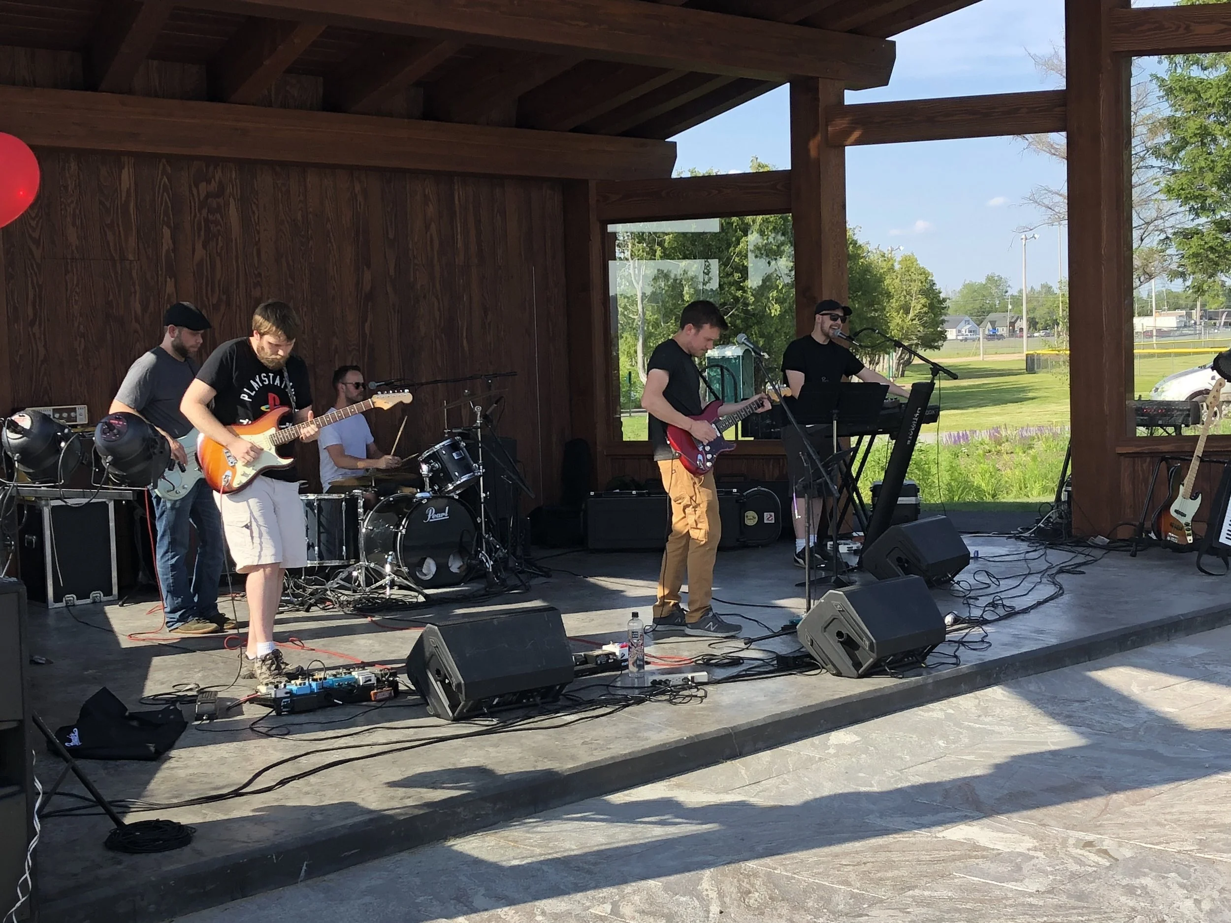 Tupper Lake's band Night School was the first entertainment group to play on what Mayor Paul Maroun has dubbed the Sunset Stage in the Lions new bandshell last Wednesday as part of a summer-long series of concerts and performances brought to Flanders Park by Tupper Arts and the Village of Tupper Lake. The band members include (from left) Micah Tyo, Jay Martin, Ian Roantree, Andrew and Ben McClelland. The menu of rock tunes served up by the local boys pleased the pallets of about 300 local listeners, relaxing in their lawn chairs and on blankets on the terraces in front of the brand new performance venue, as shown below. Photos by Dan McClelland.