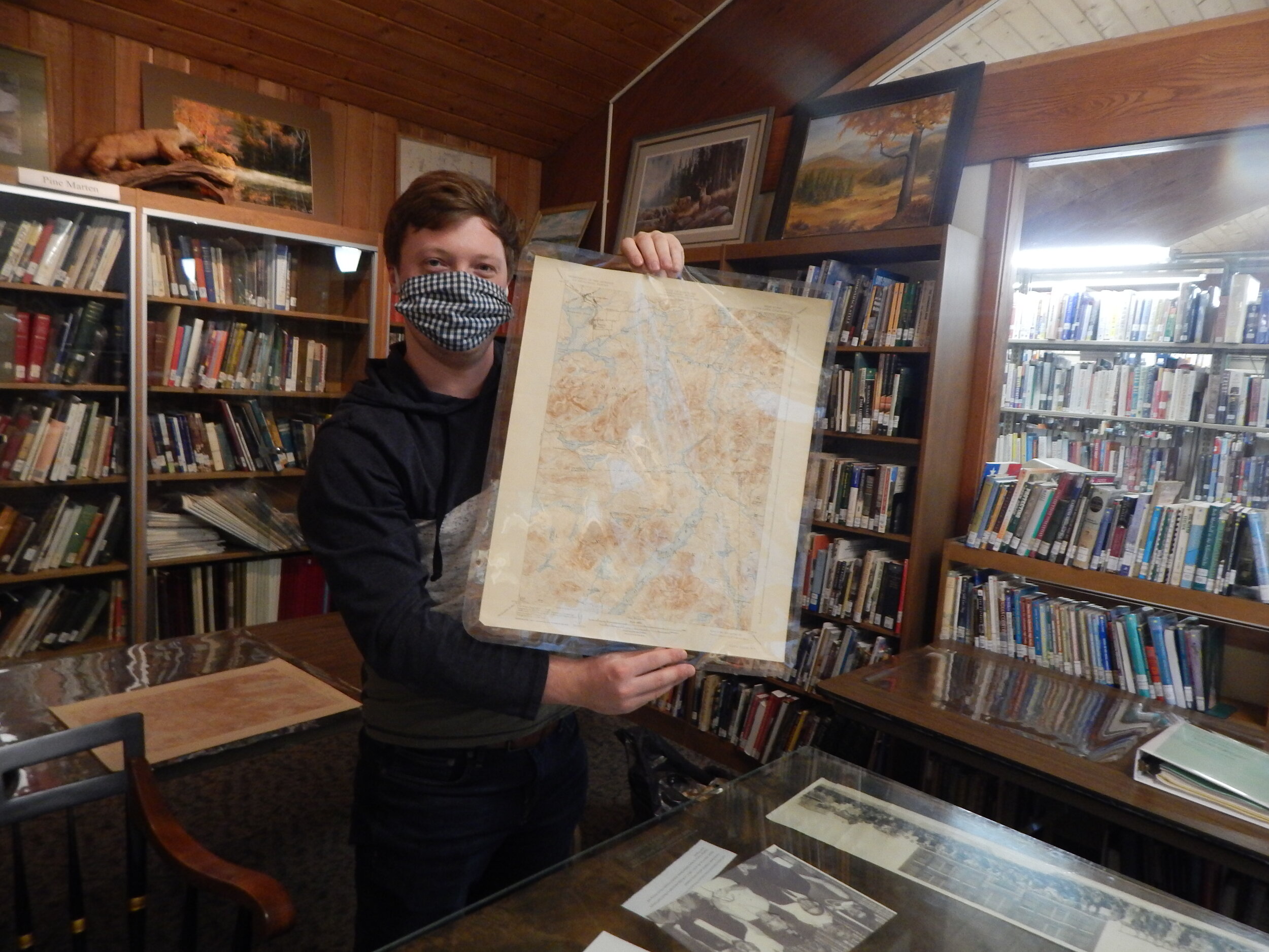    Archivist Conor Snow holds up a map he wrapped in mylar. (Rich Rosentreter photos)  