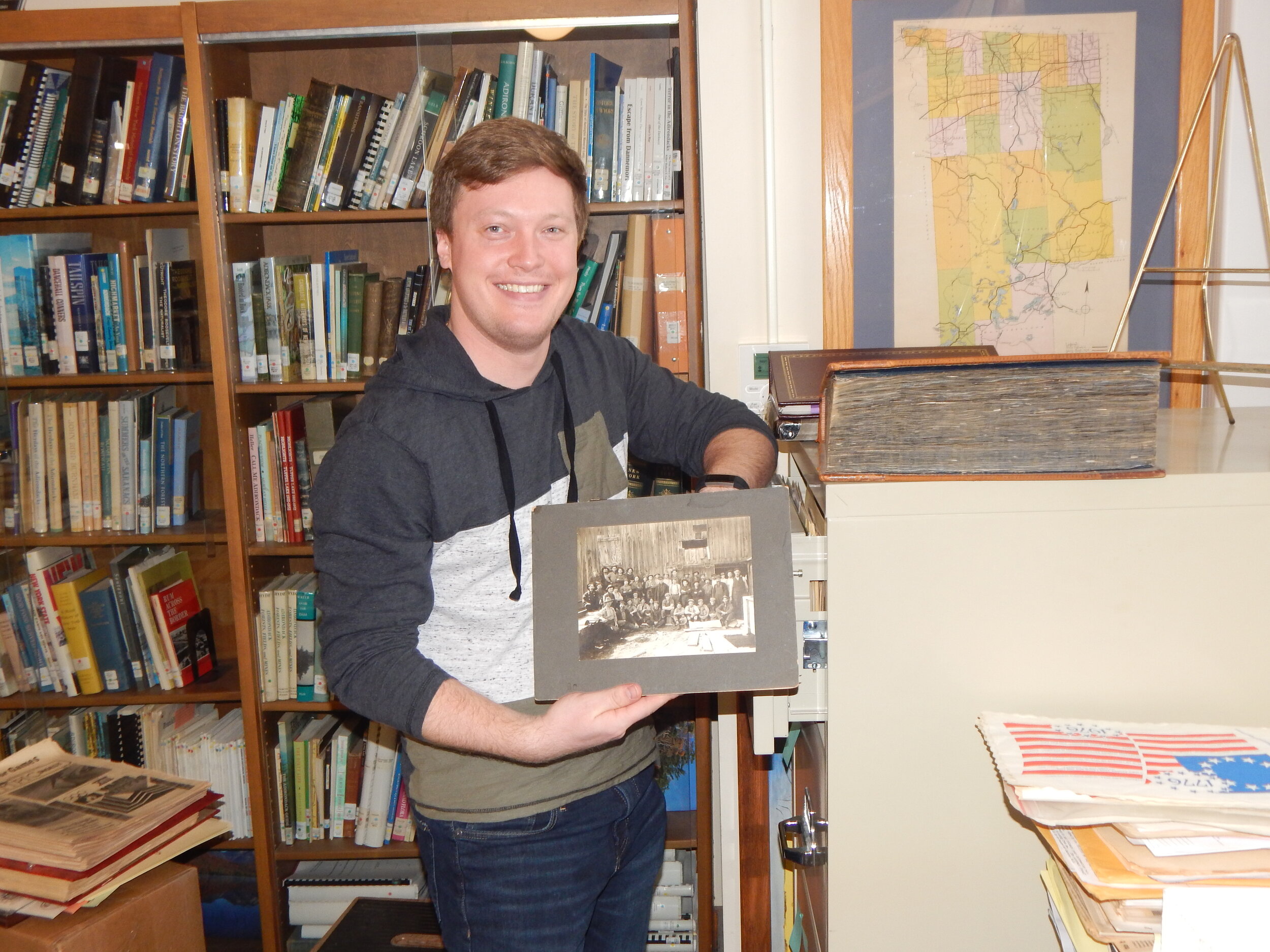   Conor holds a photograph that will be filed in the cabinet.  