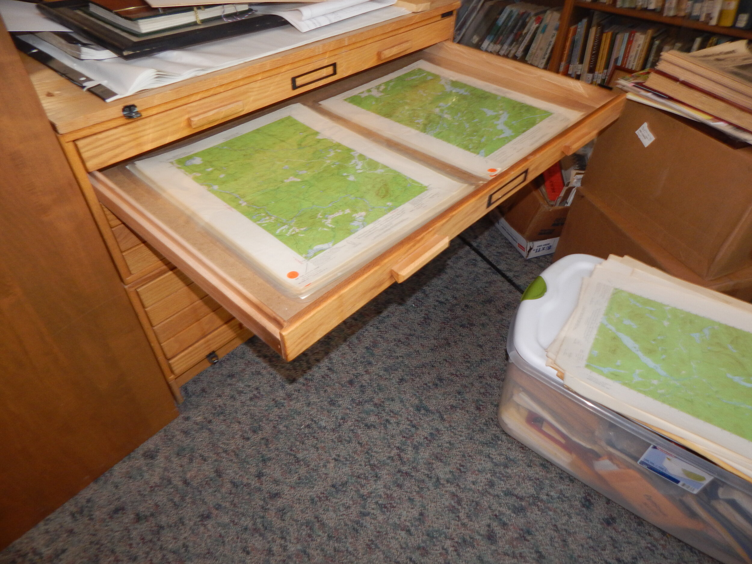    Maps are being filed away into this drawer.  