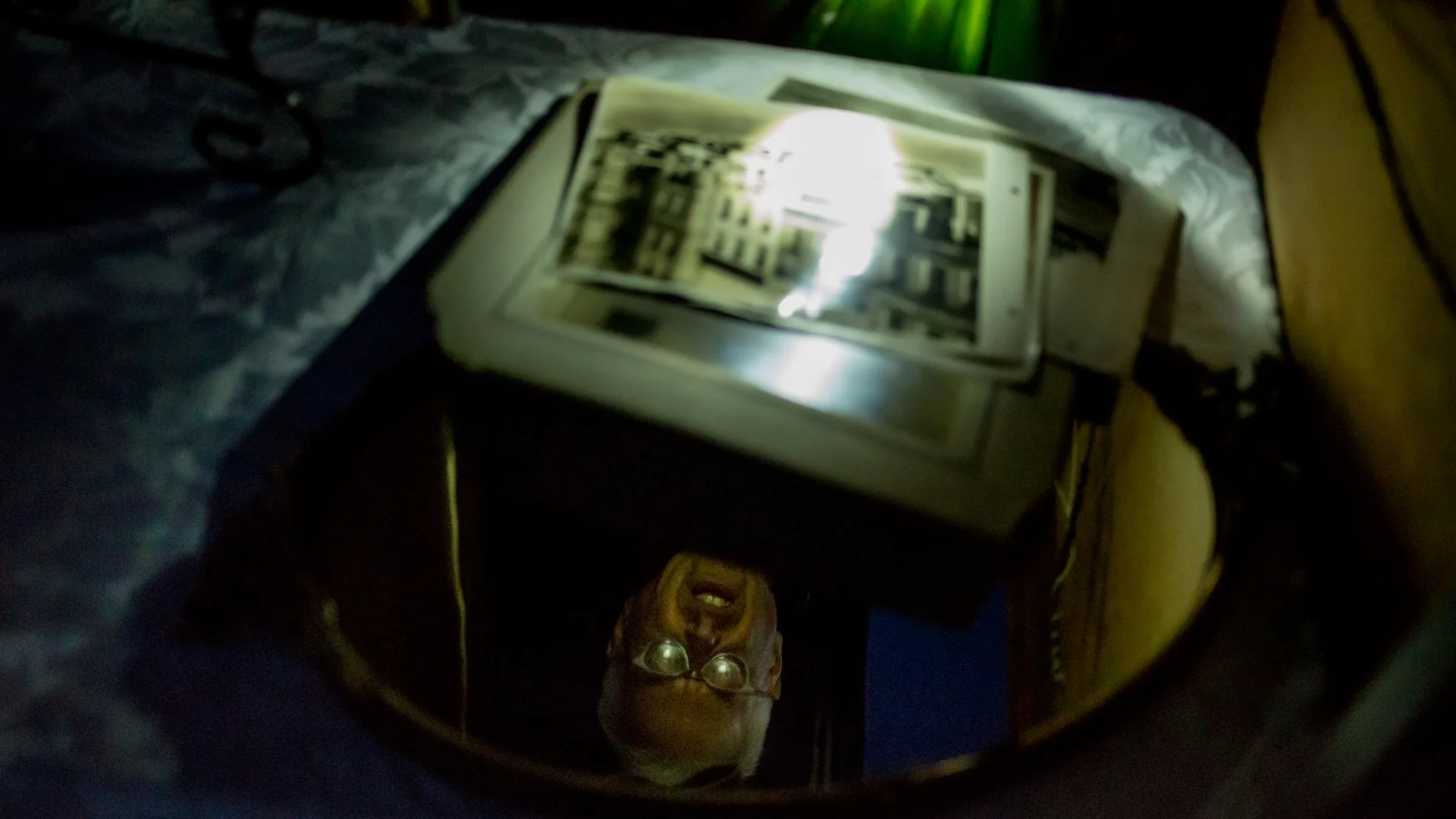 Armed with his cellphone light, he looked at some old pictures from one of the stands.