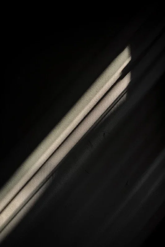 Close-up of a lit rectangular window or light fixture against a dark background, possibly a part of a building interior or exterior.