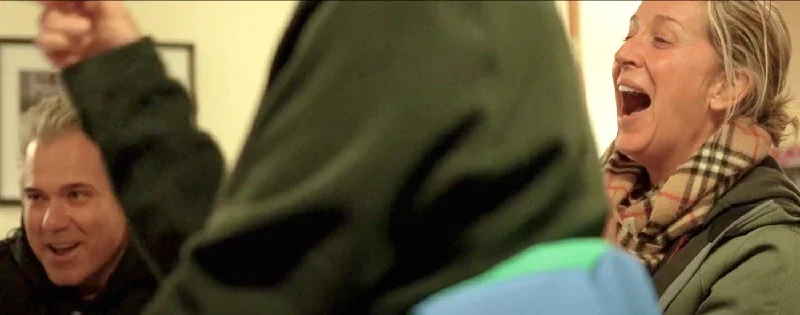 People laughing and enjoying a social moment indoors.