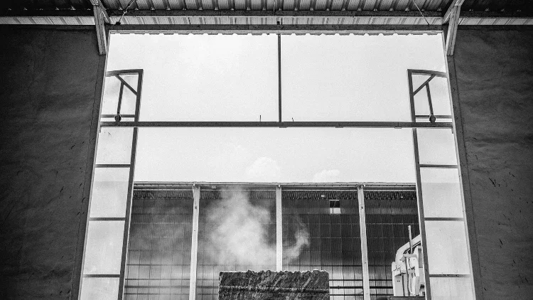 grind smoke coming out of a giant slab of uncut marble in an industrial area