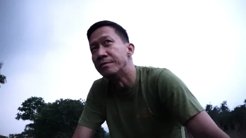 Man on the back of the truck with the afternoon sky in the background