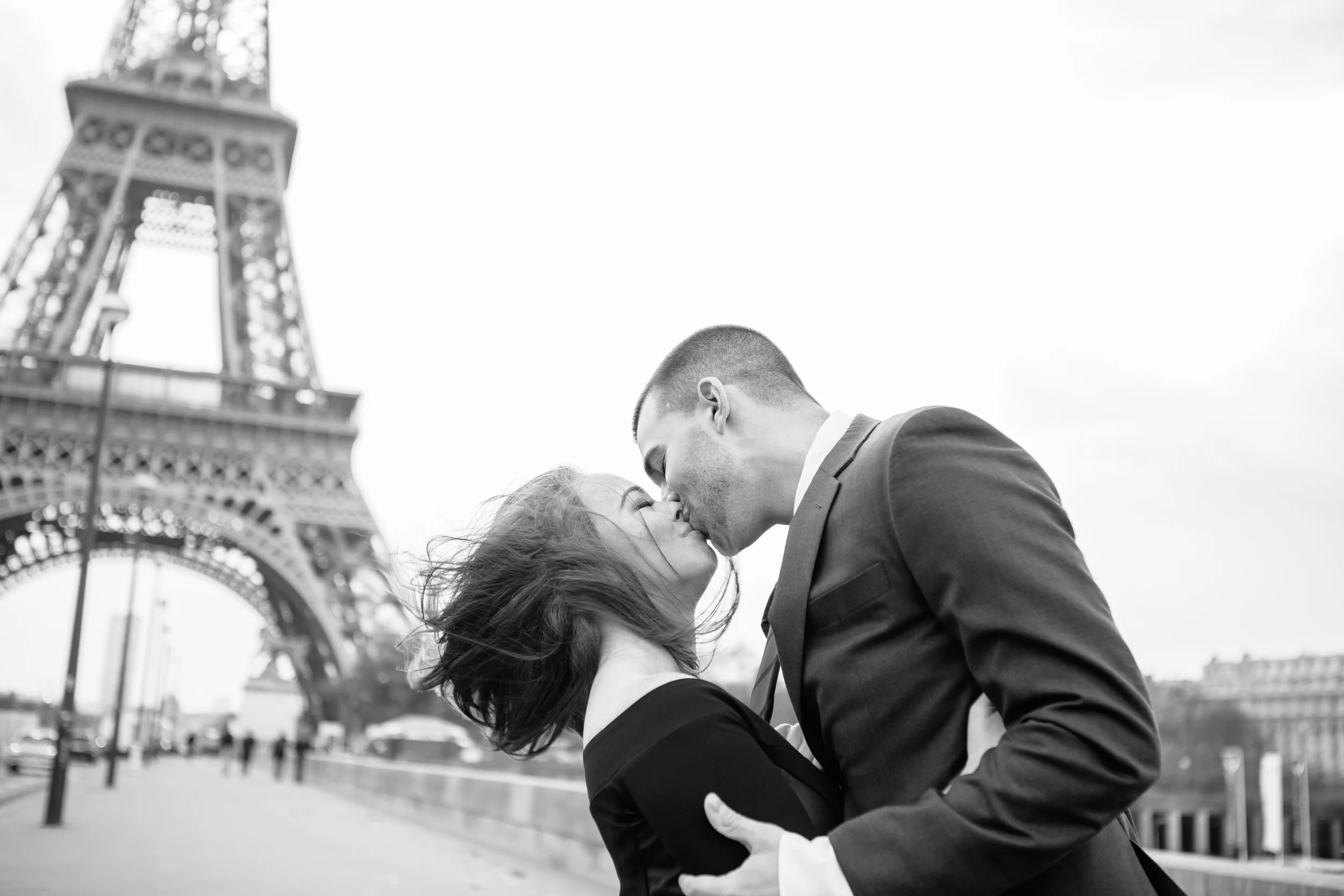 paris photographer engagement session couple kissing by the eiffel tower black and white