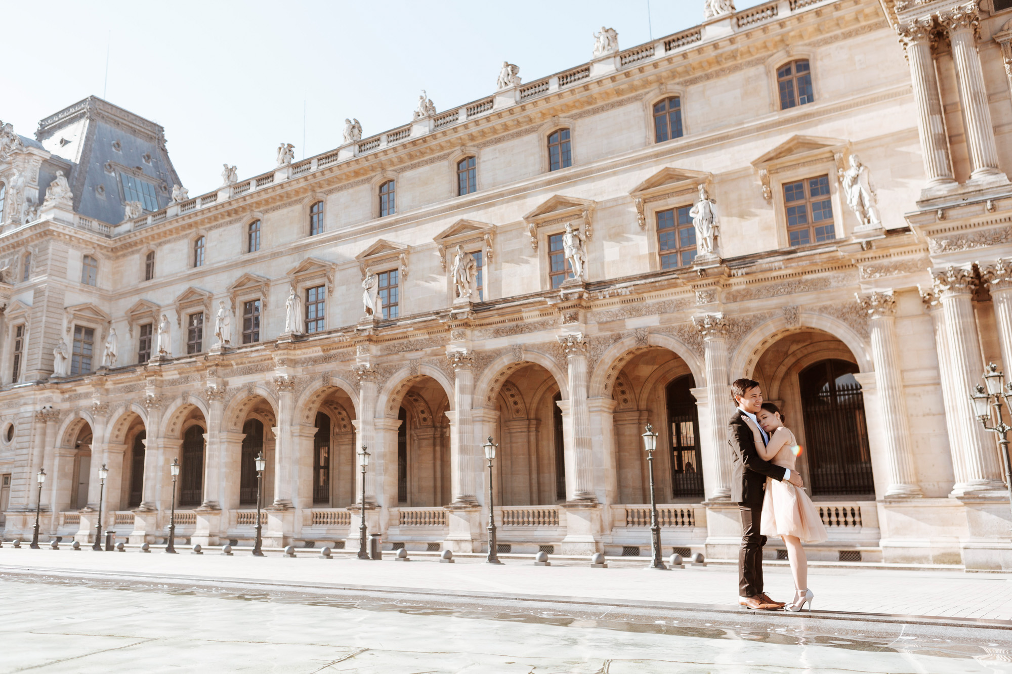Pre-wedding couple portrait at the Louvre Museum courtyard at sunrise captured by Paris Photographer Federico Guendel