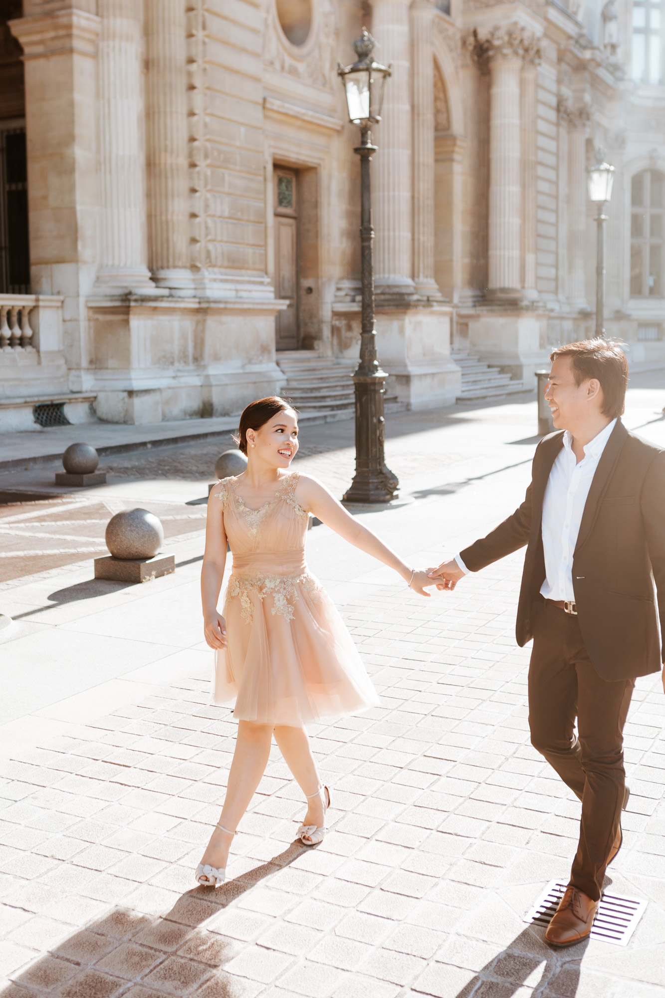 Pre-wedding couple portrait walking the courtyard of the Louvre Museum captured by Paris Photographer Federico Guendel