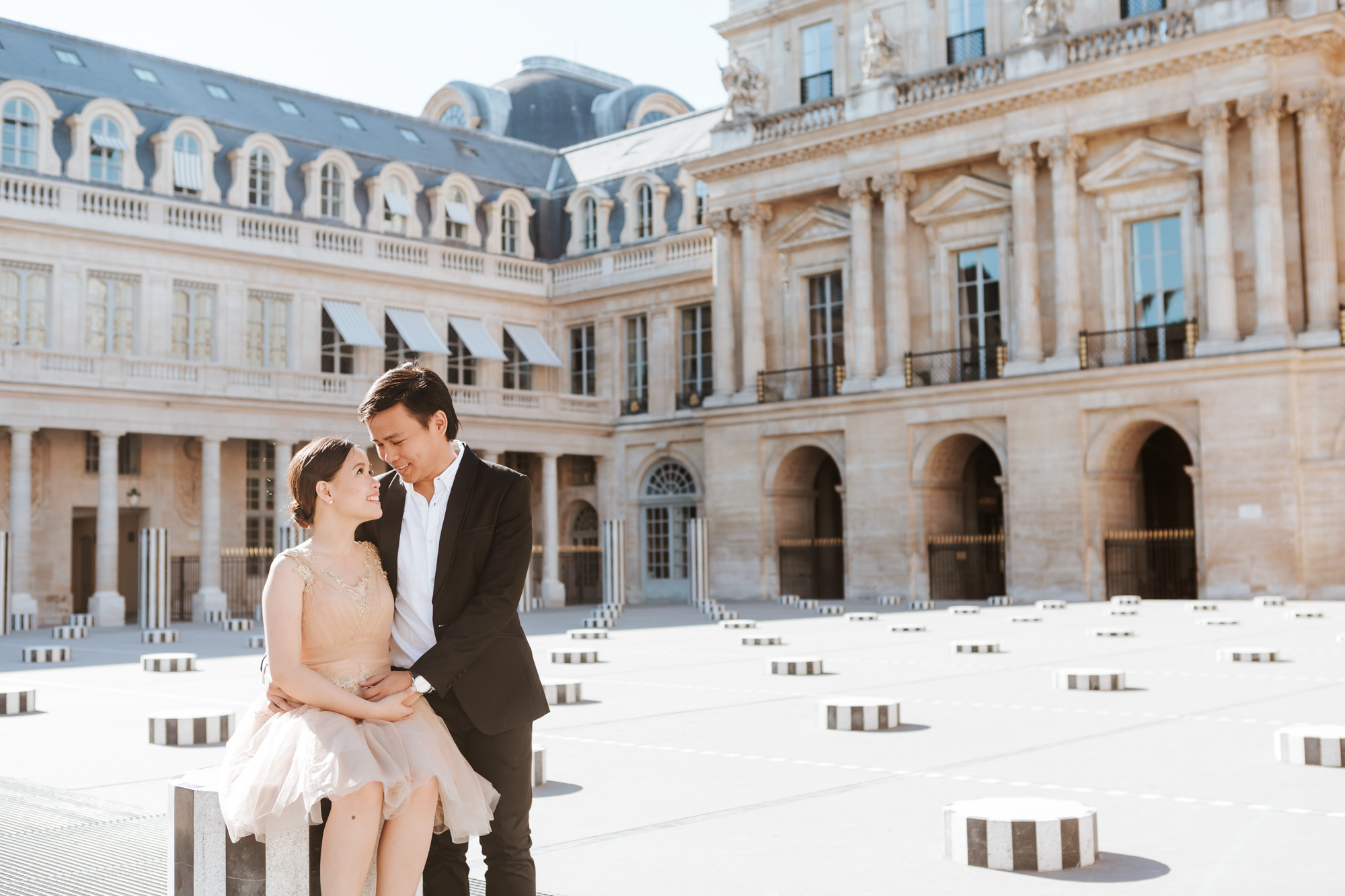 Pre-wedding couple portrait sitting in the courtyard of Palais Royal captured by Paris Photographer Federico Guendel