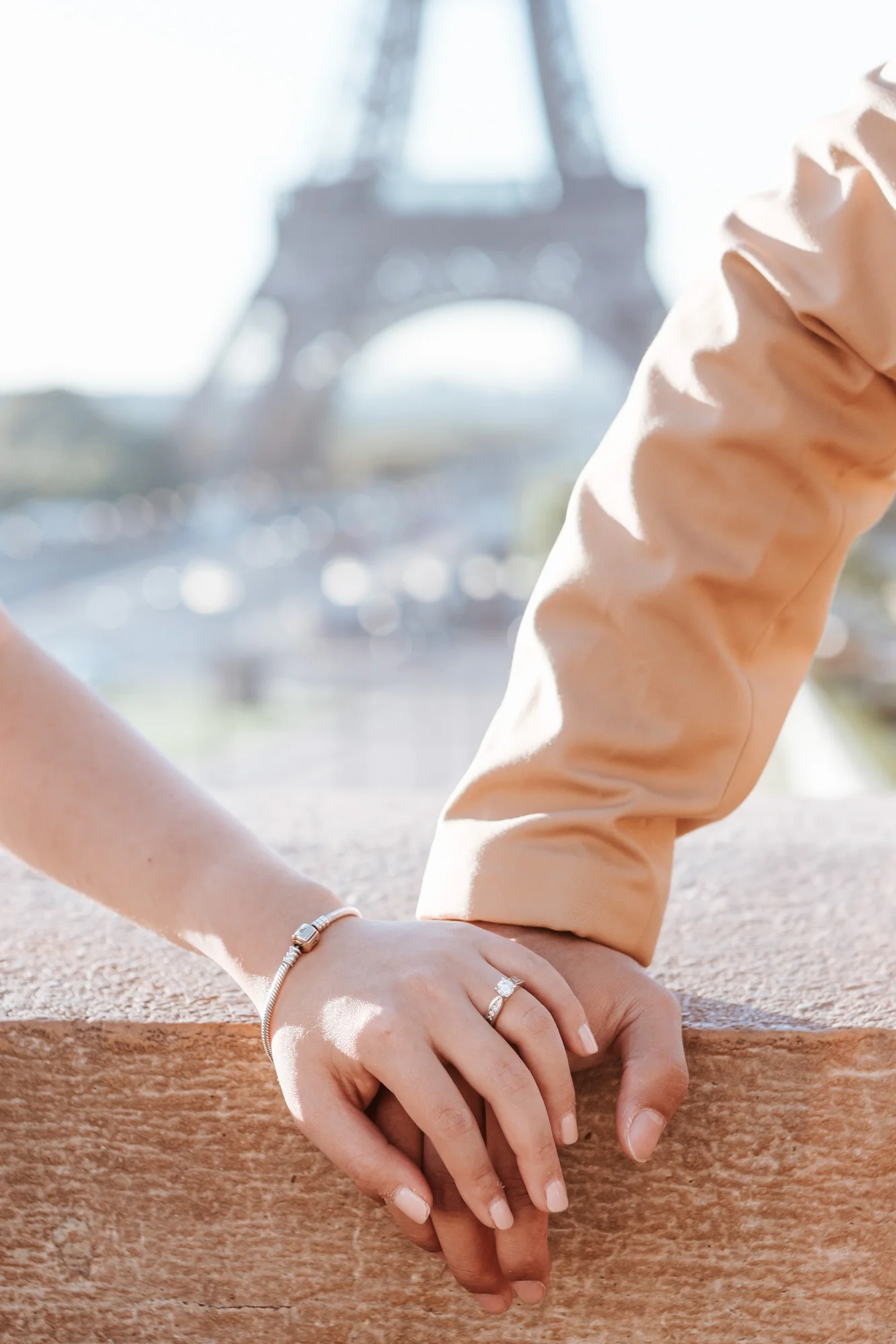 Pre-wedding couple holding hands with engagement ring by the Eiffel Tower in sunrise captured by Photographer in Paris Federico Guendel