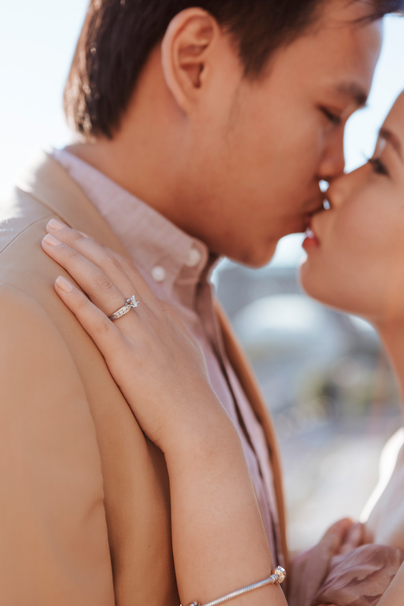 Pre-wedding couple portrait with engagement ring at the Eiffel Tower kissing in sunrise captured by Photographer in Paris Federico Guendel
