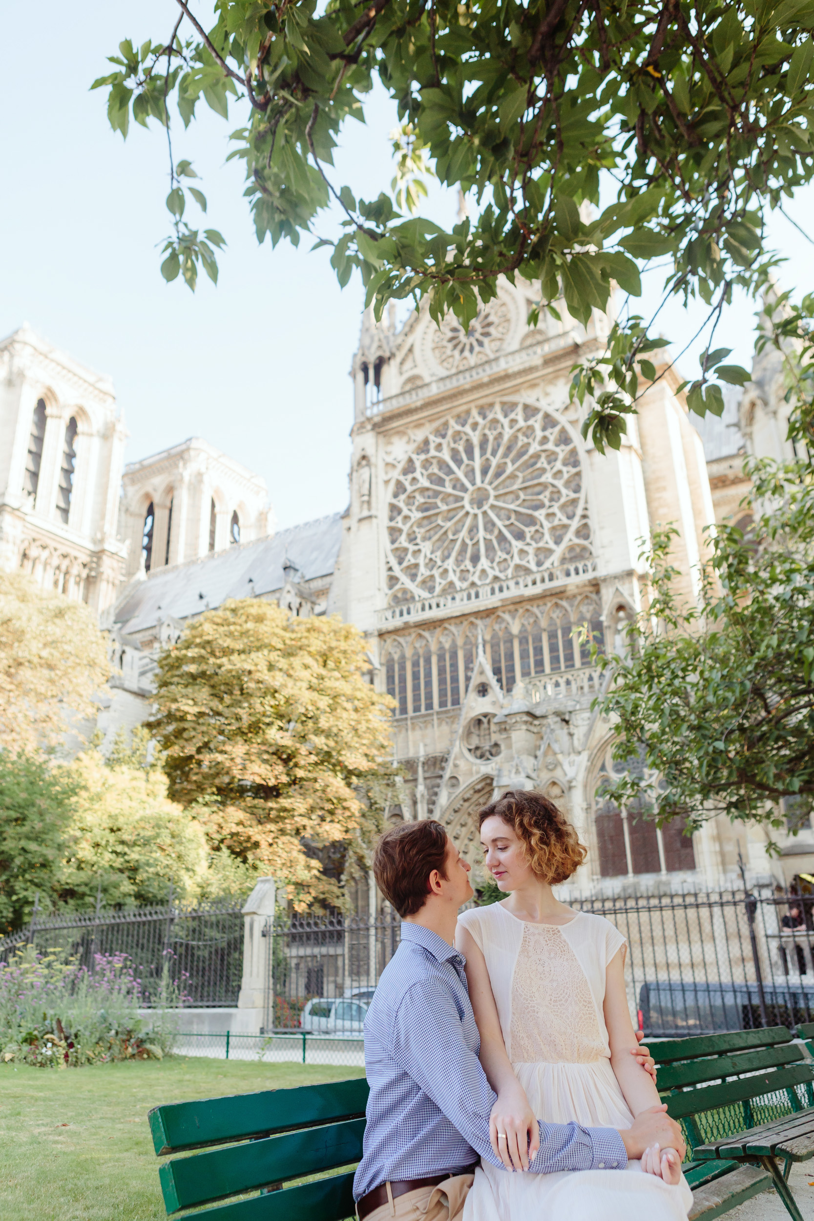 Couple in love sitting on a bench by Notre Dame Cathedral in Paris captured by Paris Photographer Federico Guendel IheartParisFr