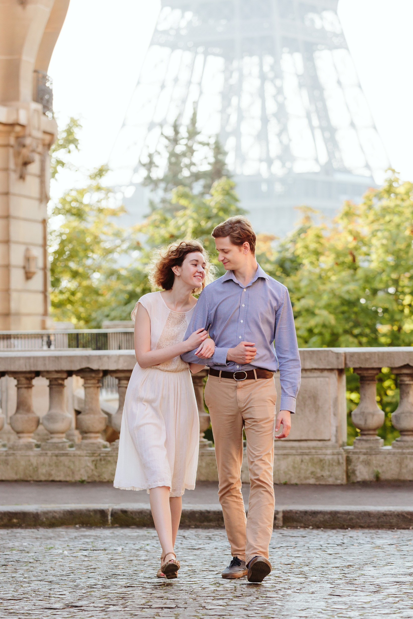 Travel love story couple walking next to Eiffel Tower at Passy captured by Paris Photographer Federico Guendel IheartParisFr