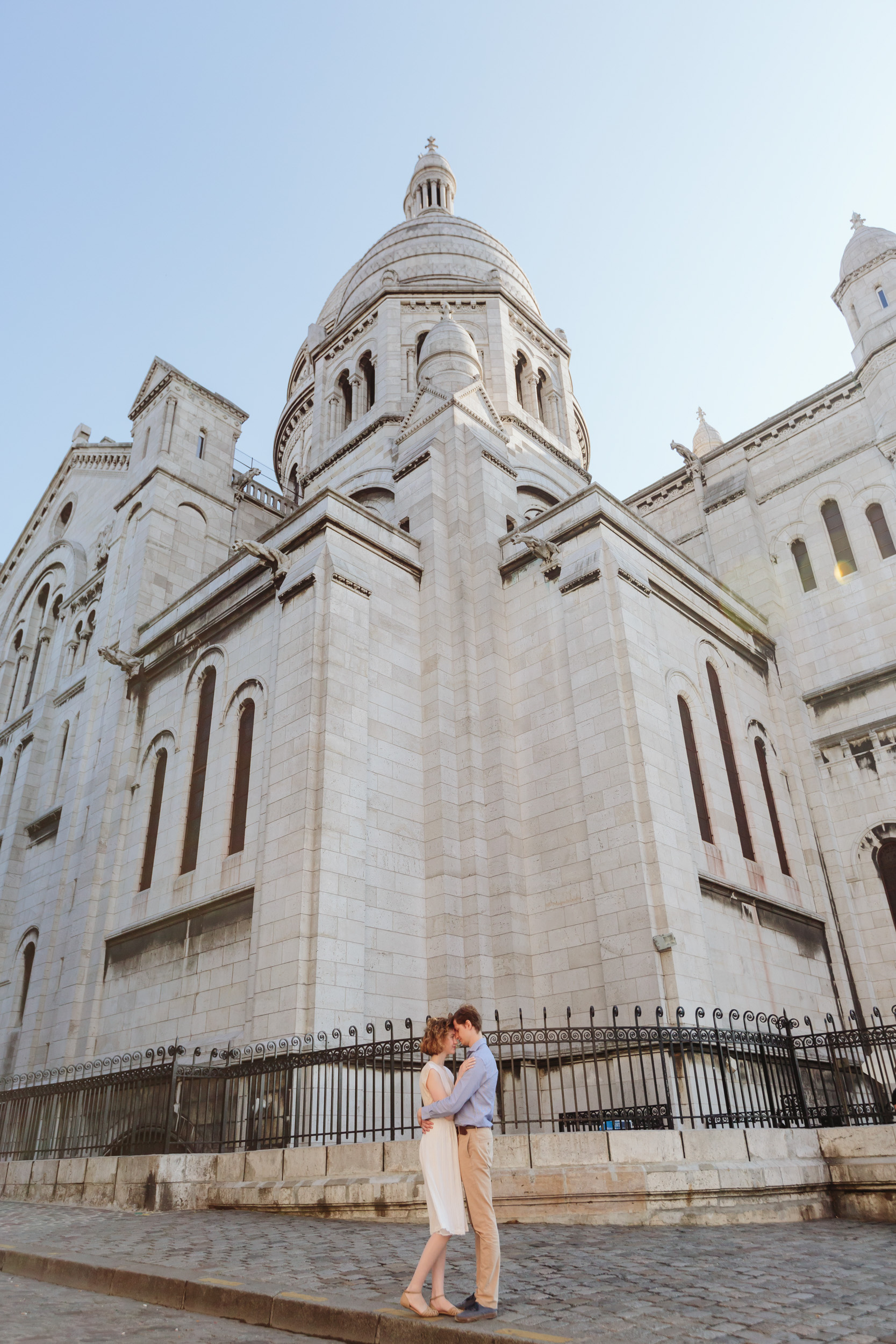 Couple in love standing by Sacre Coeur Cathedral at Montmartre captured by Paris Photographer Federico Guendel IheartParisFr
