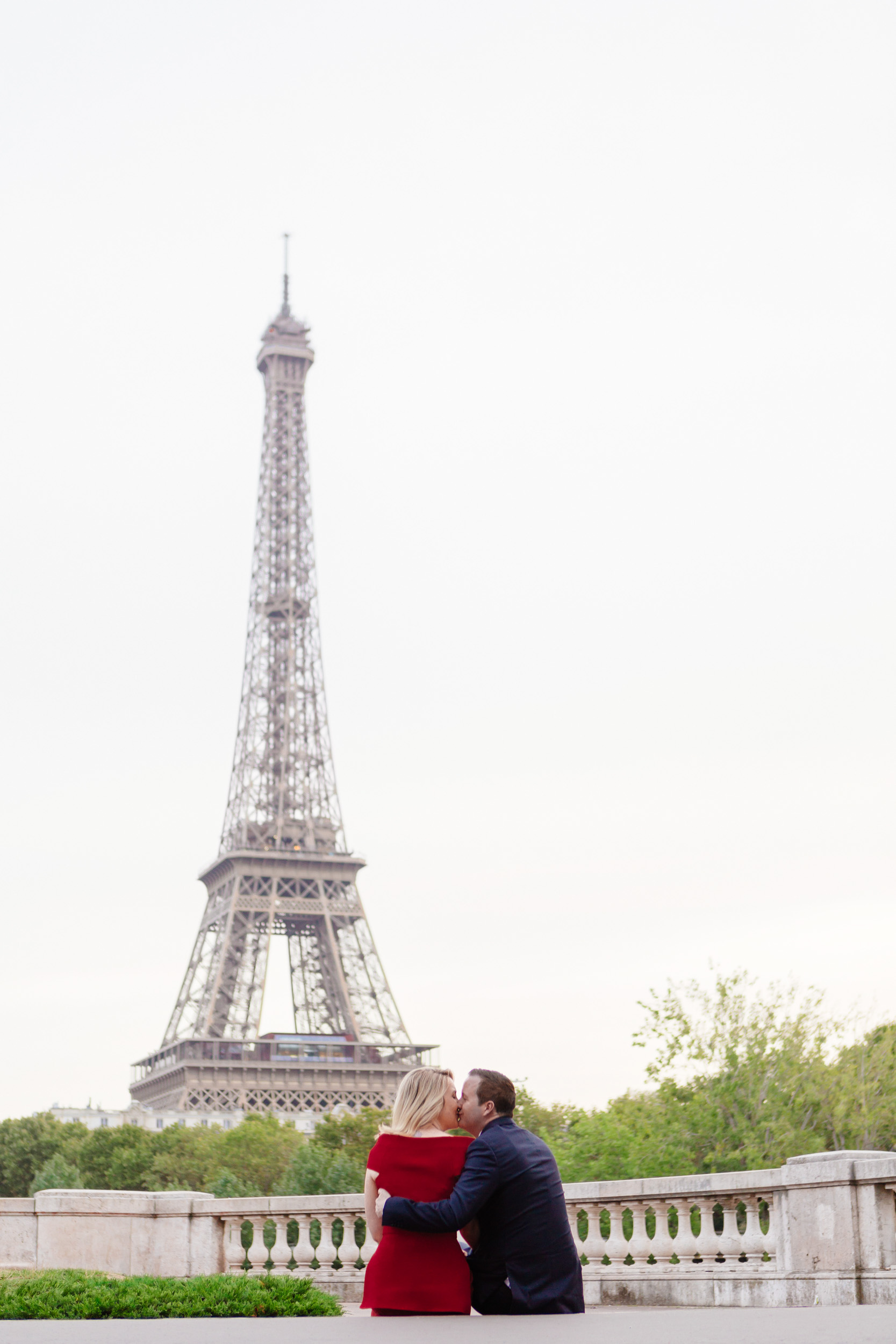 Romantic portrait of a couple kissing at bridge Bir Hakeim with the view of the Eiffel Tower captured by Paris Photographer Federico Guendel www.iheartparis.fr