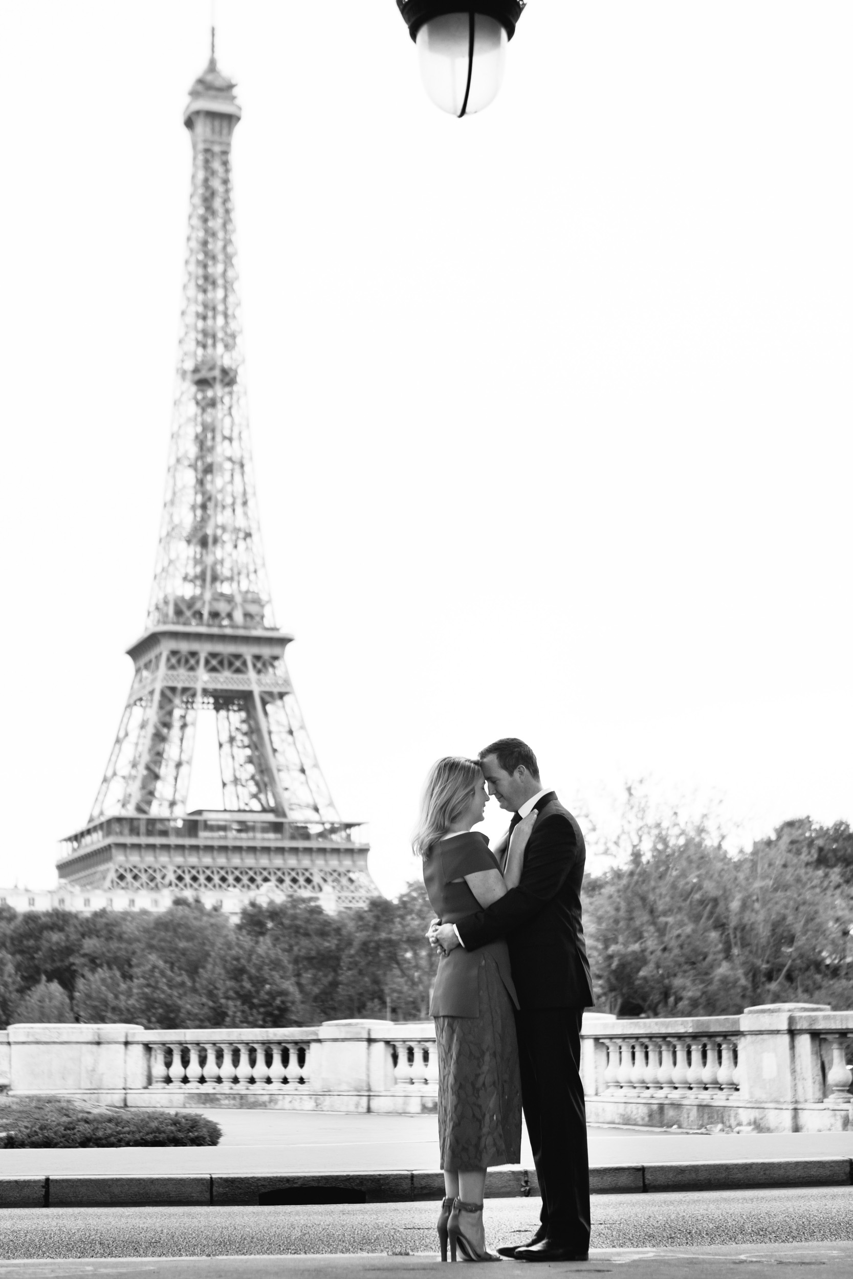 Romantic black and white portrait of a couple at bridge Bir Hakeim with the view of the Eiffel Tower captured by Paris Photographer Federico Guendel www.iheartparis.fr
