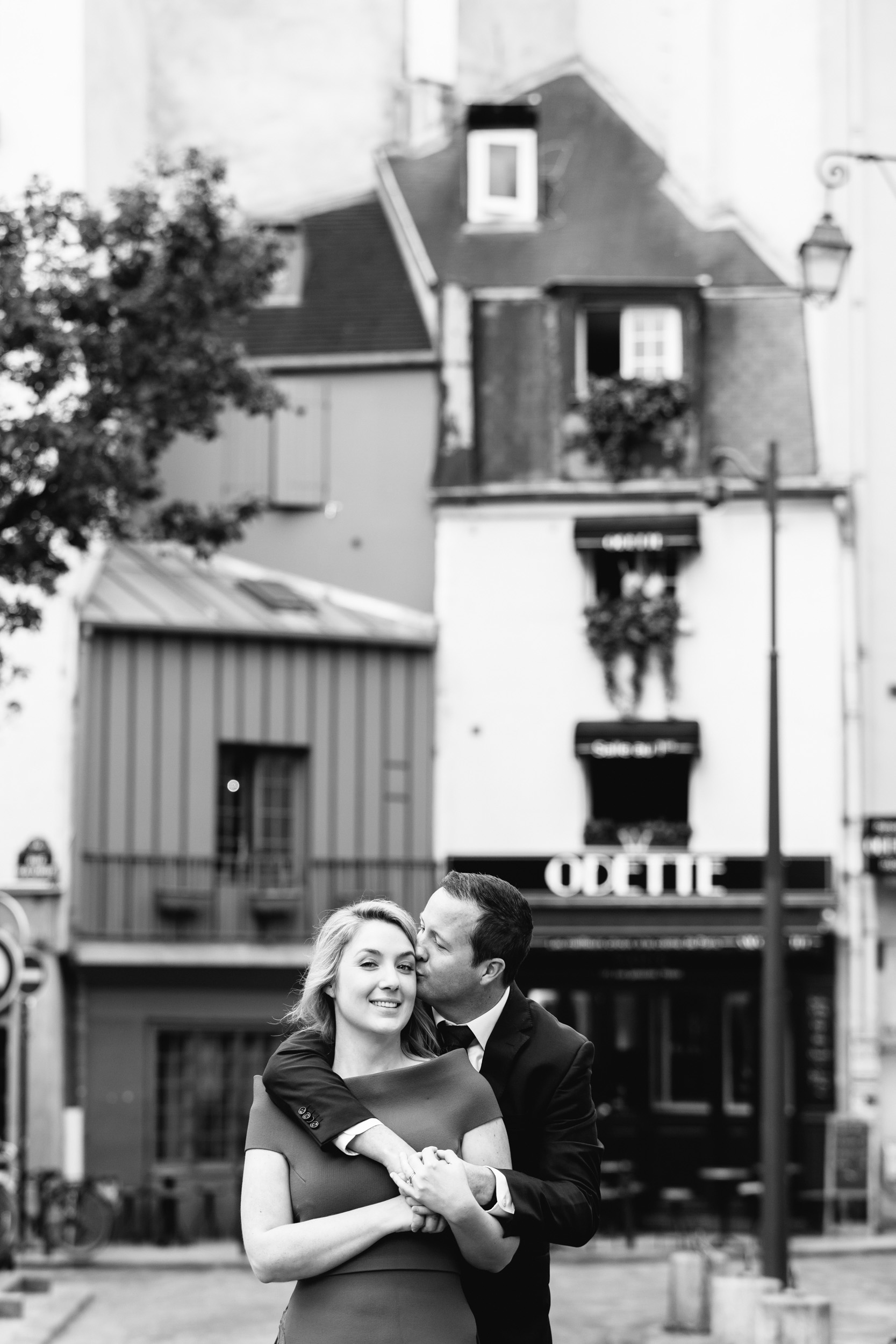 Romantic black and white portrait of a couple hugging in front of cafe Odette in Saint Germain captured by Paris Photographer Federico Guendel www.iheartparis.fr