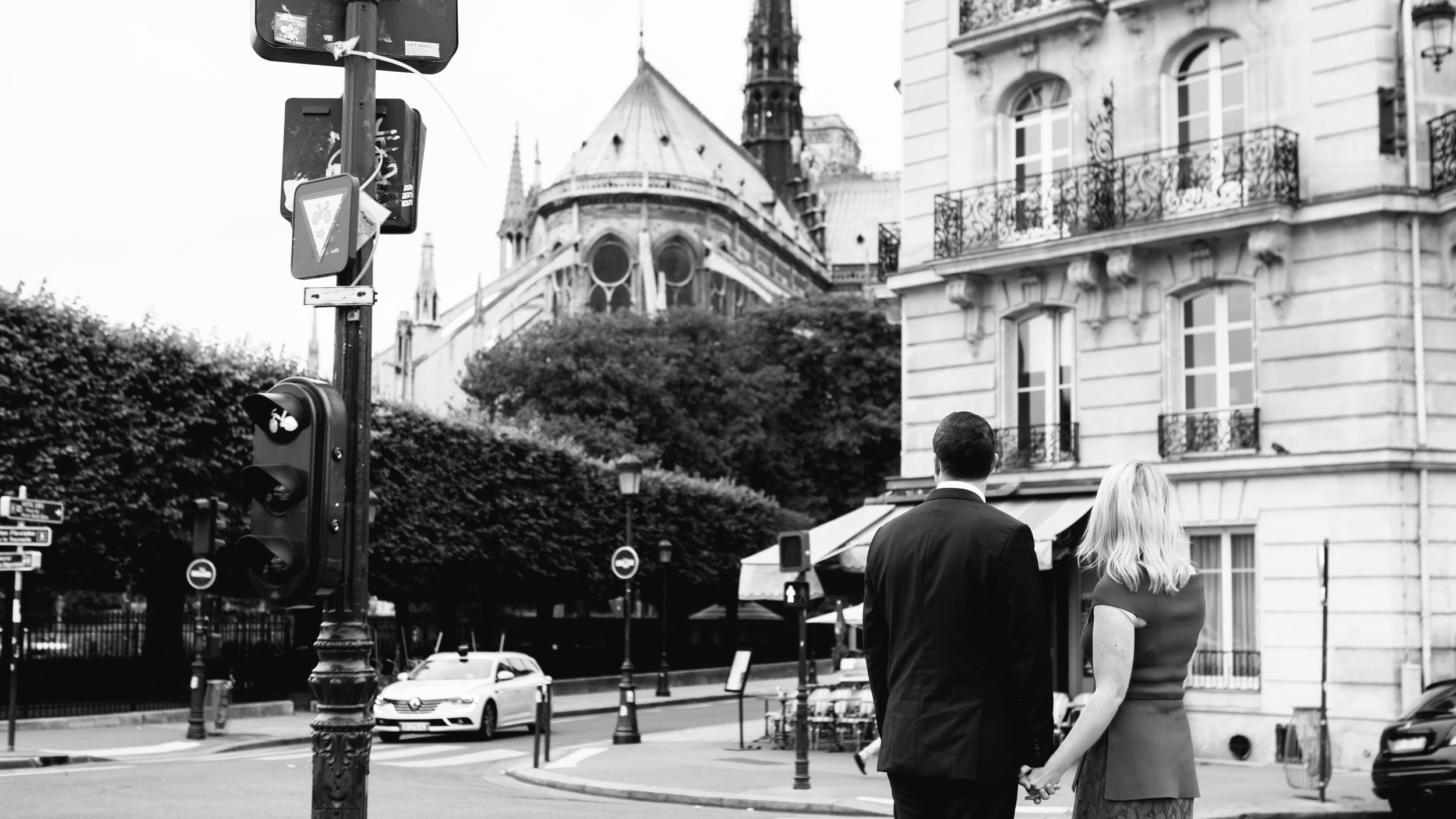 Romantic black and white portrait of a couple holding hands with the view of Notre Dame Cathedral captured by Paris Photographer Federico Guendel www.iheartparis.fr