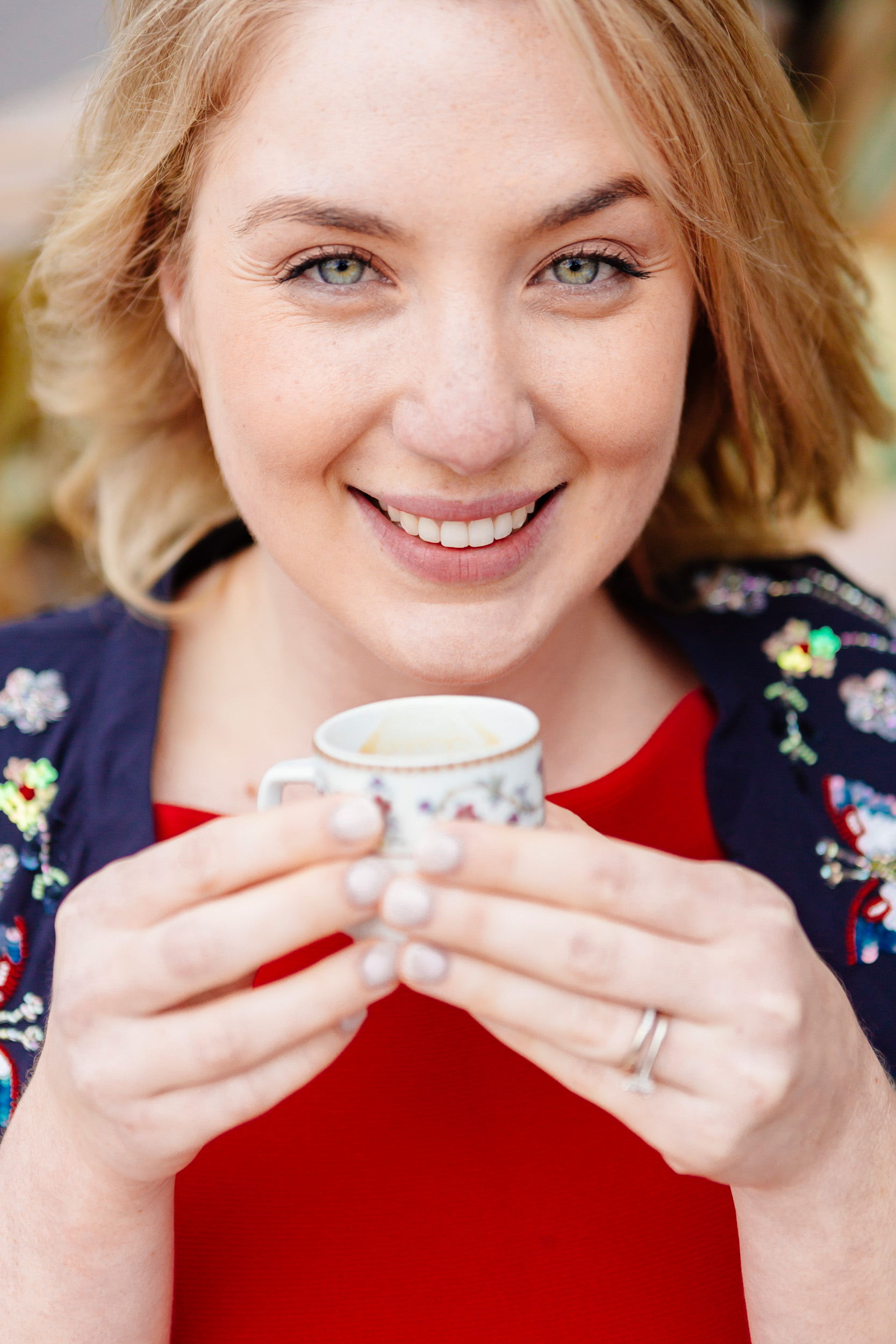 Beautiful woman holding coffee cup and smiling at cafe Esmeralda captured by Paris Photographer Federico Guendel www.iheartparis.fr