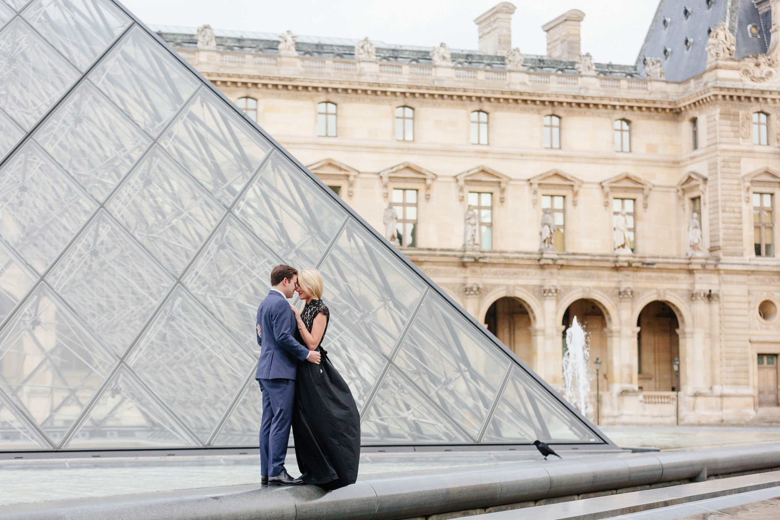 Paris vacation couple portrait hugging by Louvre Museum Pyramid captured by Paris Photographer Federico Guendel www.iheartparis.fr