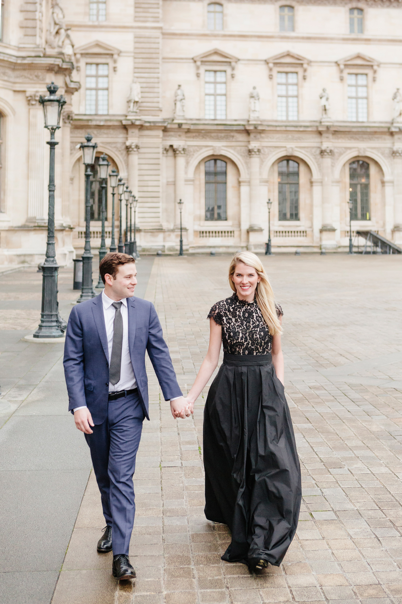 Paris vacation couple portrait holding hands in the courtyard of Louvre Museum captured by Paris Photographer Federico Guendel www.iheartparis.fr