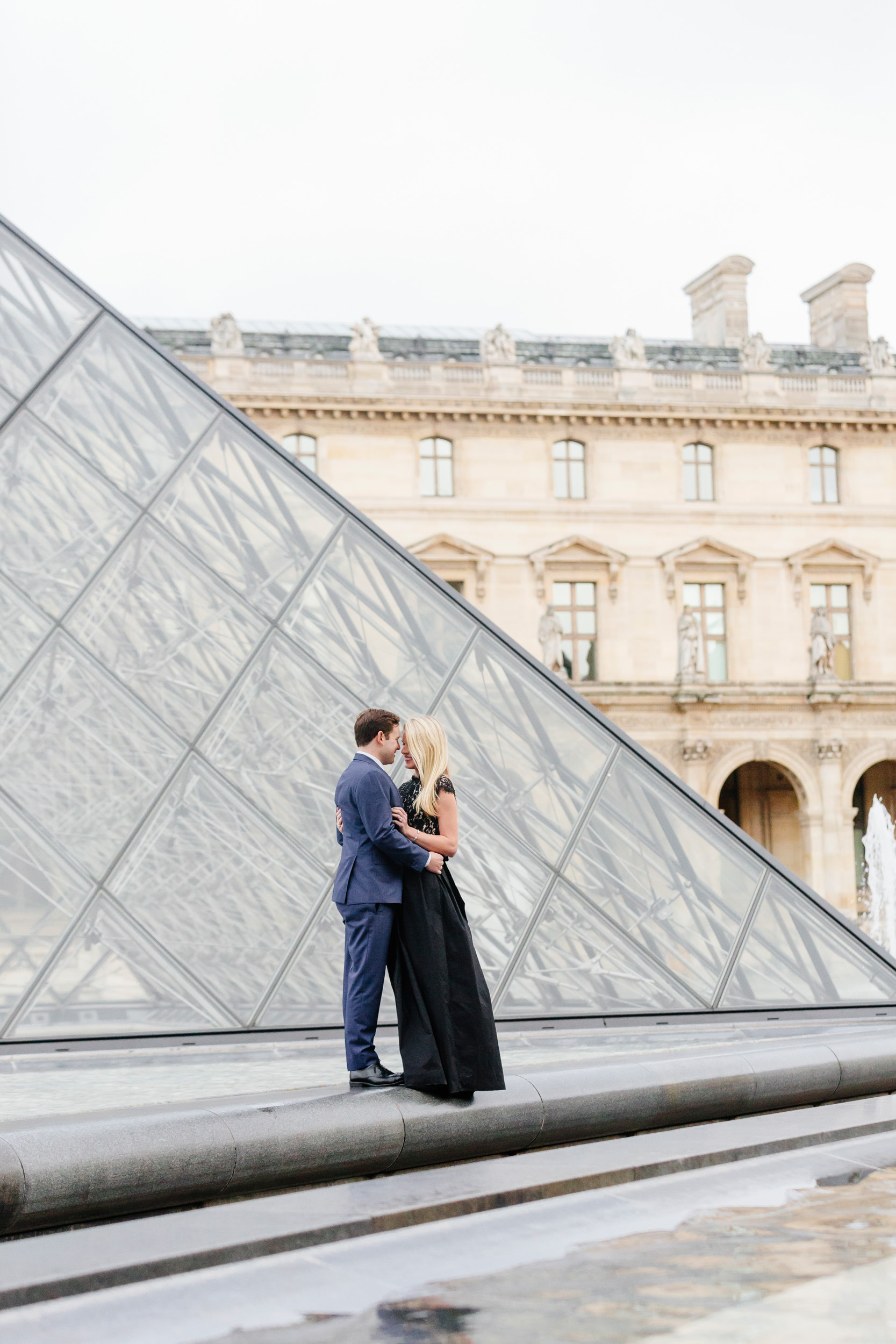 Paris vacation couple portrait standing by the Louvre Museum Pyramid captured by Paris Photographer Federico Guendel www.iheartparis.fr