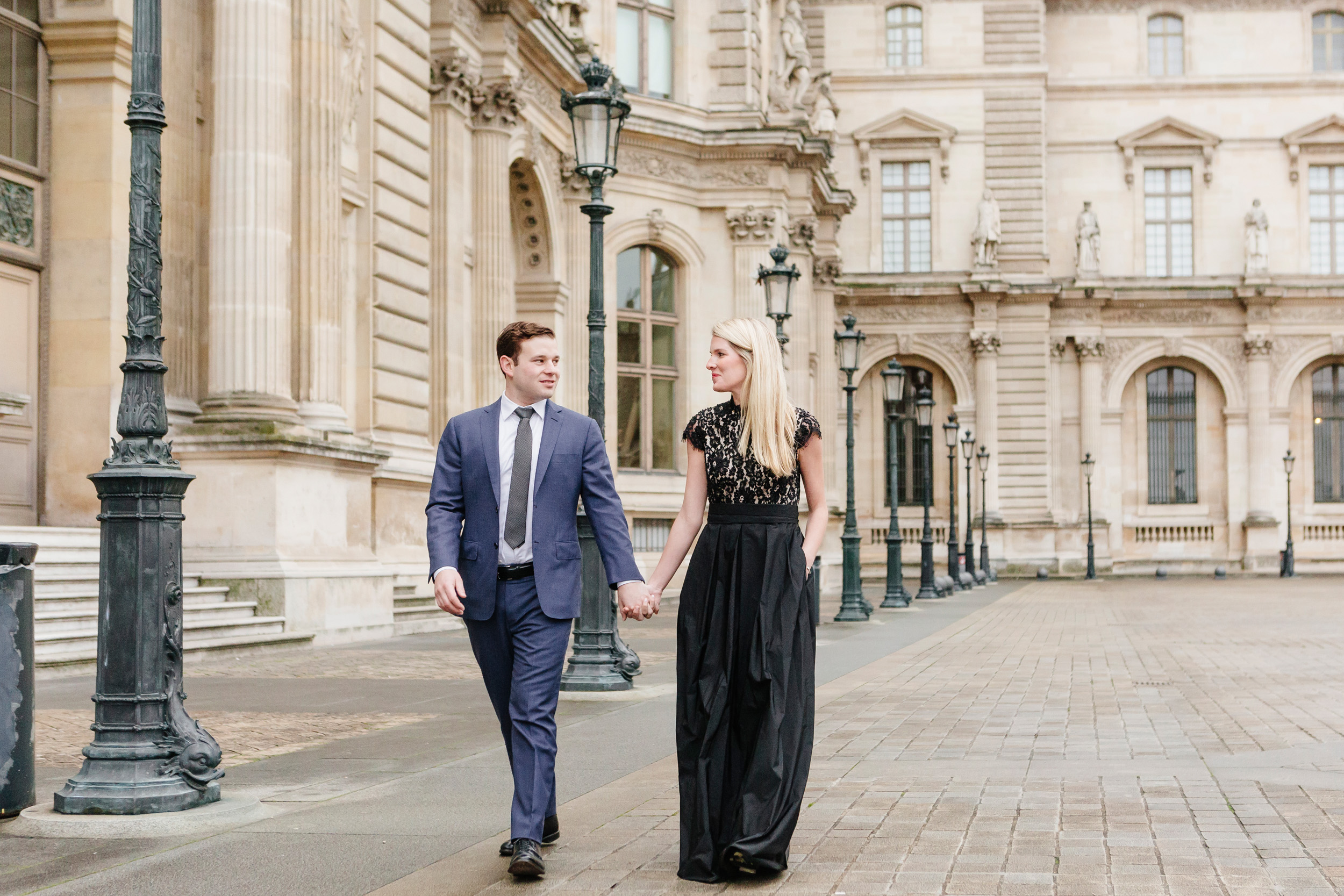 Paris vacation couple portrait holding hands in the courtyard of Louvre Museum captured by Paris Photographer Federico Guendel www.iheartparis.fr