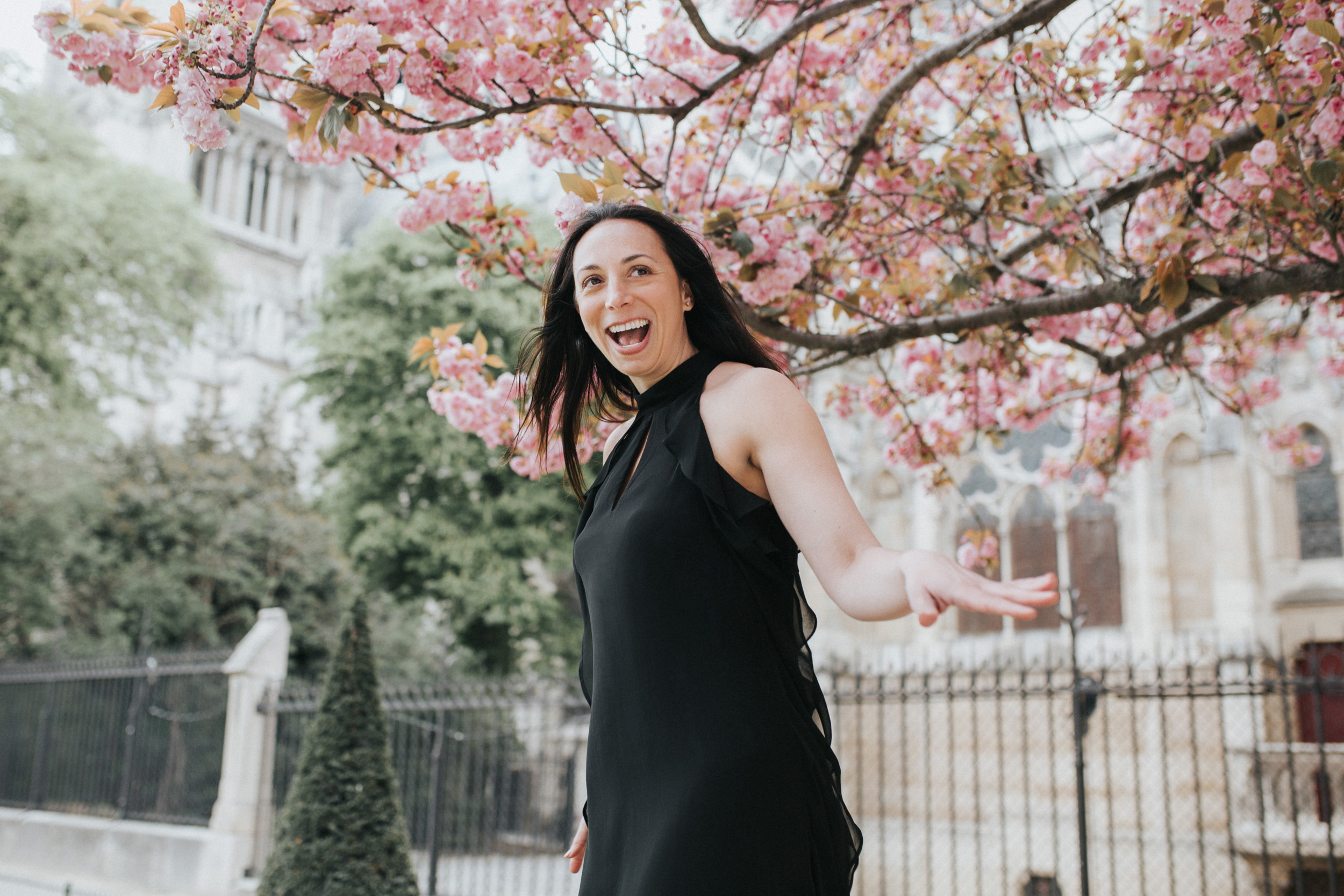 Spring portrait of Rebecca Plotnick founder of Every Day Parisian blog in front of Notre Dame and cherry blossoms captured by Paris Photographer Federico and Anastasia Guendel IheartParisFr TheFlyingPoodle