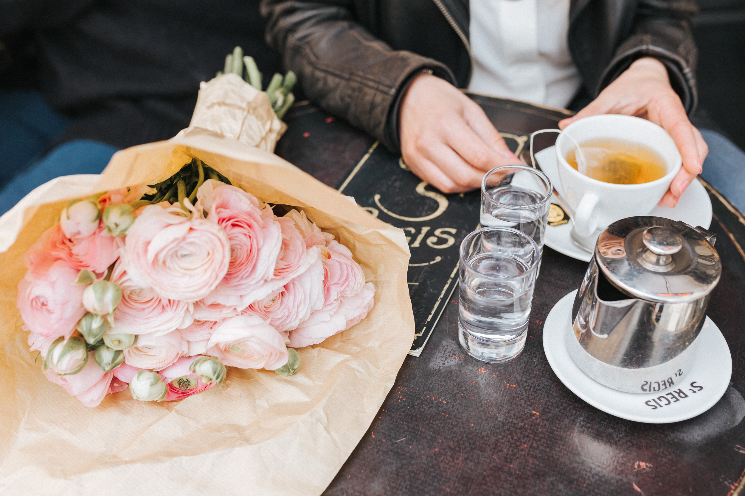 Portrait of Rebecca Plotnick founder of Every Day Parisian blog sitting at Cafe St Regis with bouquet of ranunculus captured by Paris Photographer Federico and Anastasia Guendel IheartParisFr TheFlyingPoodle
