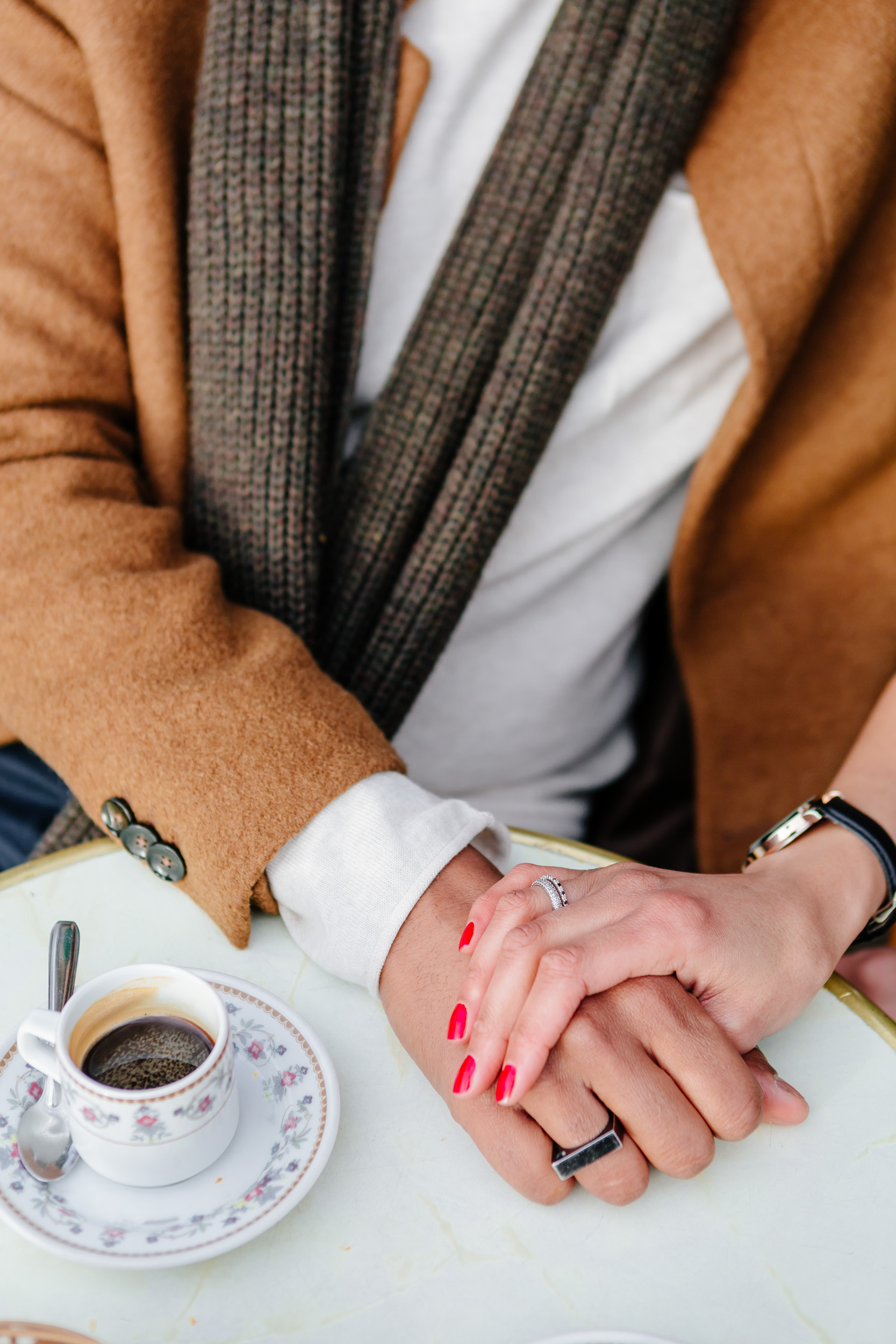 Close up of a couple holding hands at cafe Esmeralda captured by Paris Photographer Federico Guendel IheartParis www.iheartparis.fr