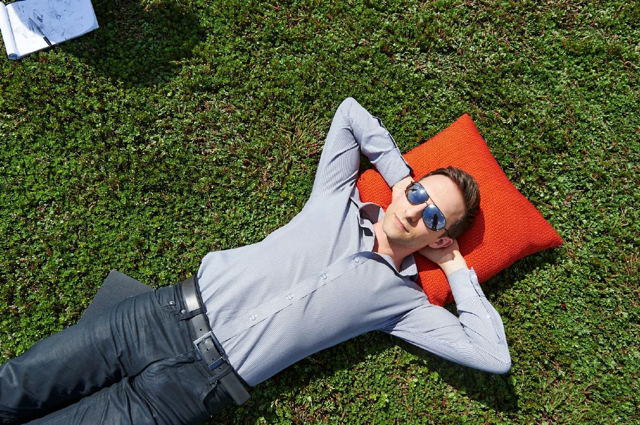 Designer Nicolai Czumaj-Bront lounges in the sun on top of Haworth headquarter's green roof in Holland, Michigan.