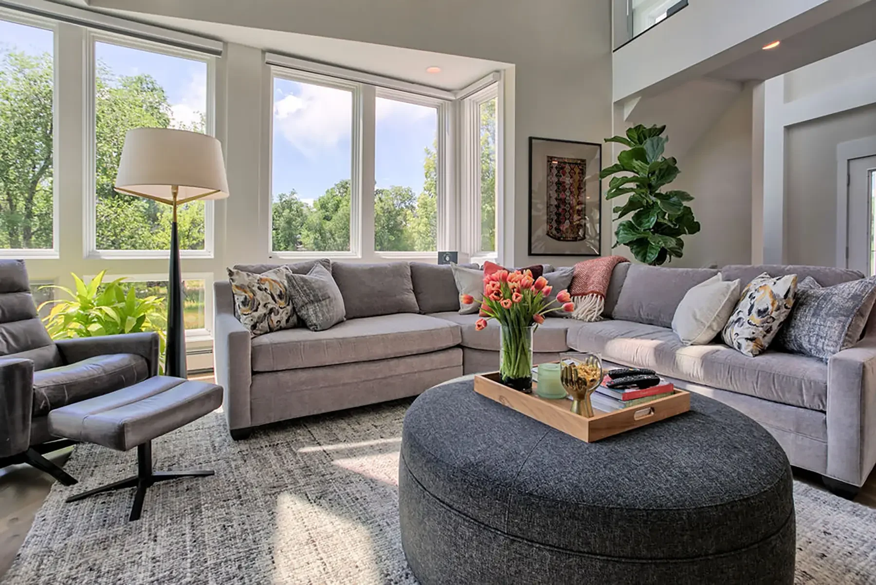 A cozy, bright living room with a sofa, chair, lamp, and decorations.