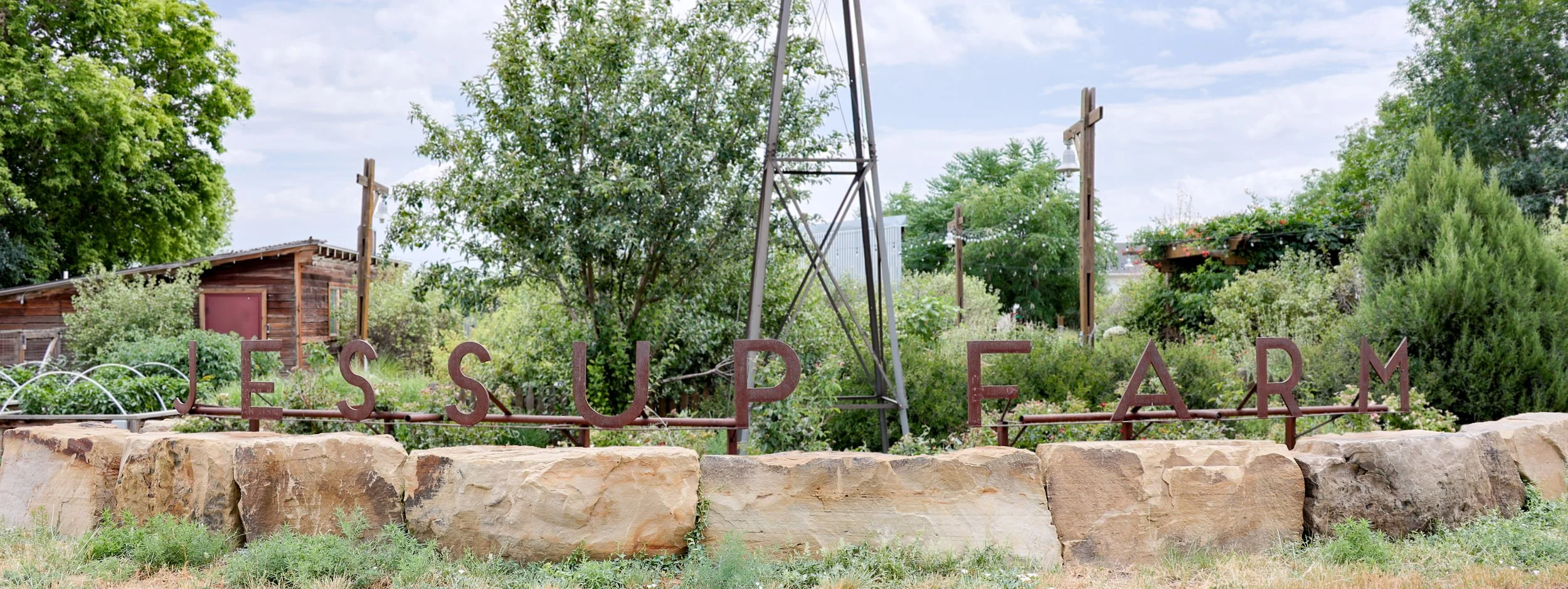A metal sign on a rock wall reading "Jessup Farm".
