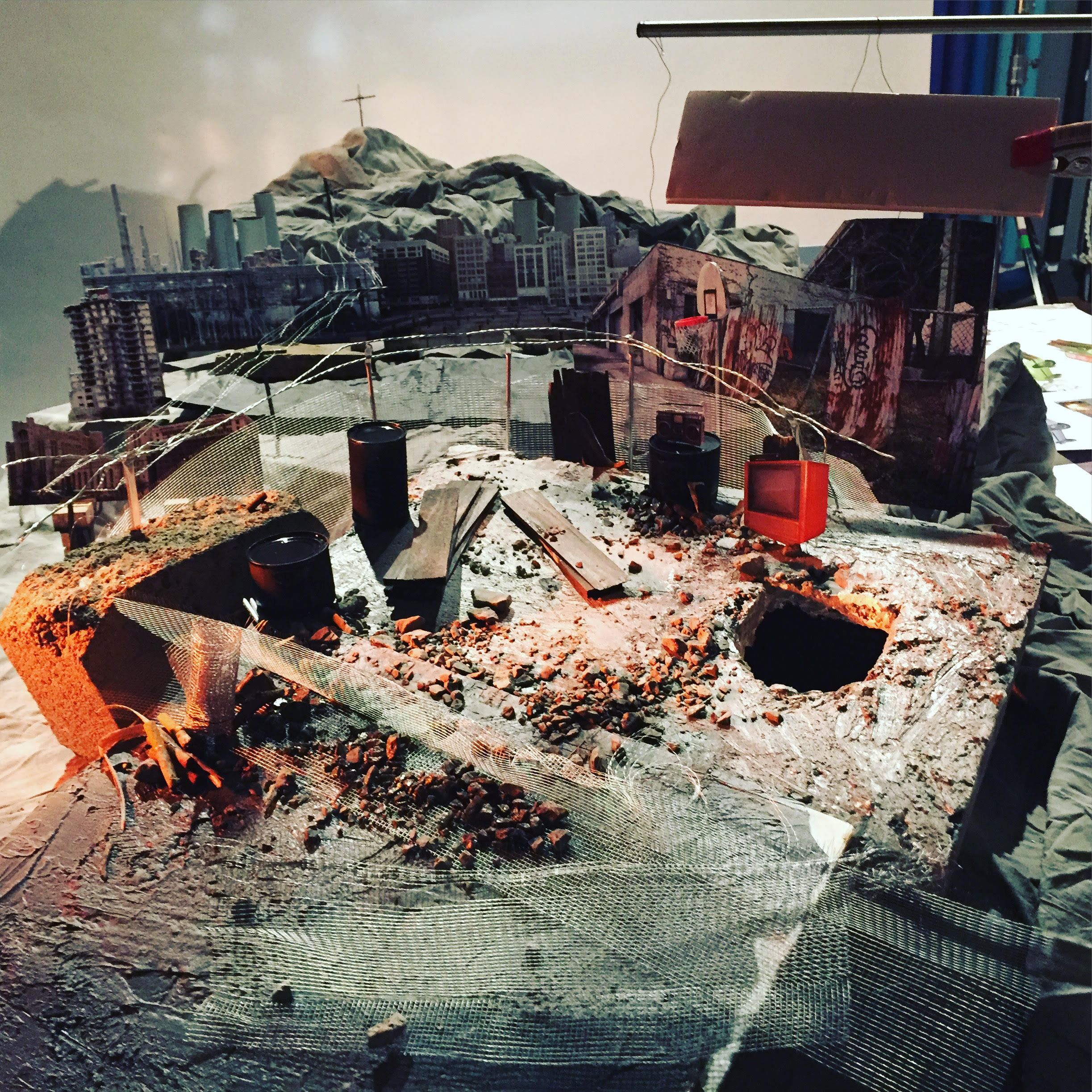 Behind the scenes: mountains of crumpled background fabric, cutout buildings for a city background, vegetable cans spray-painted black for rubbish barrels.